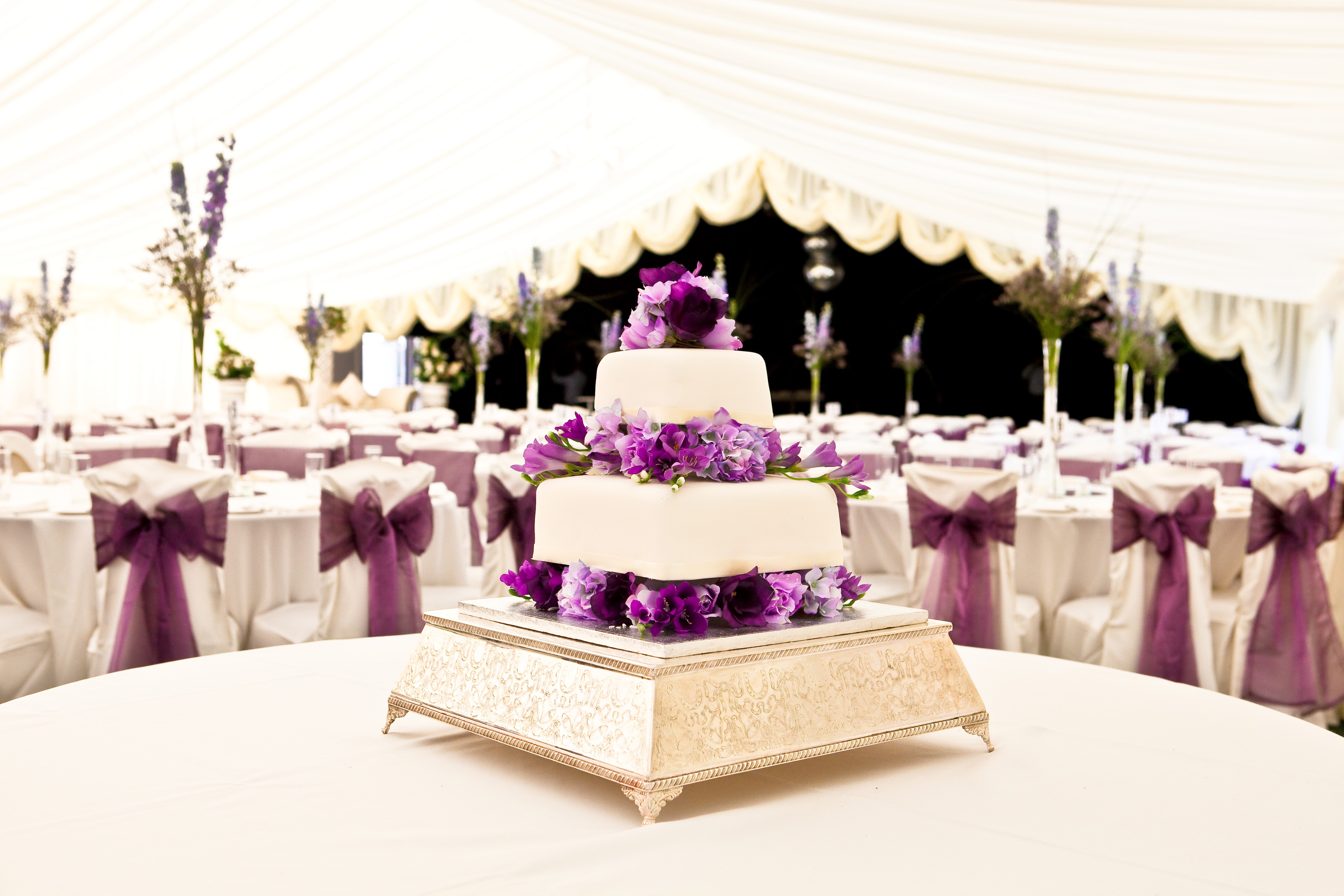 Wedding cake with purple flowers in a tent HD Wallpaper