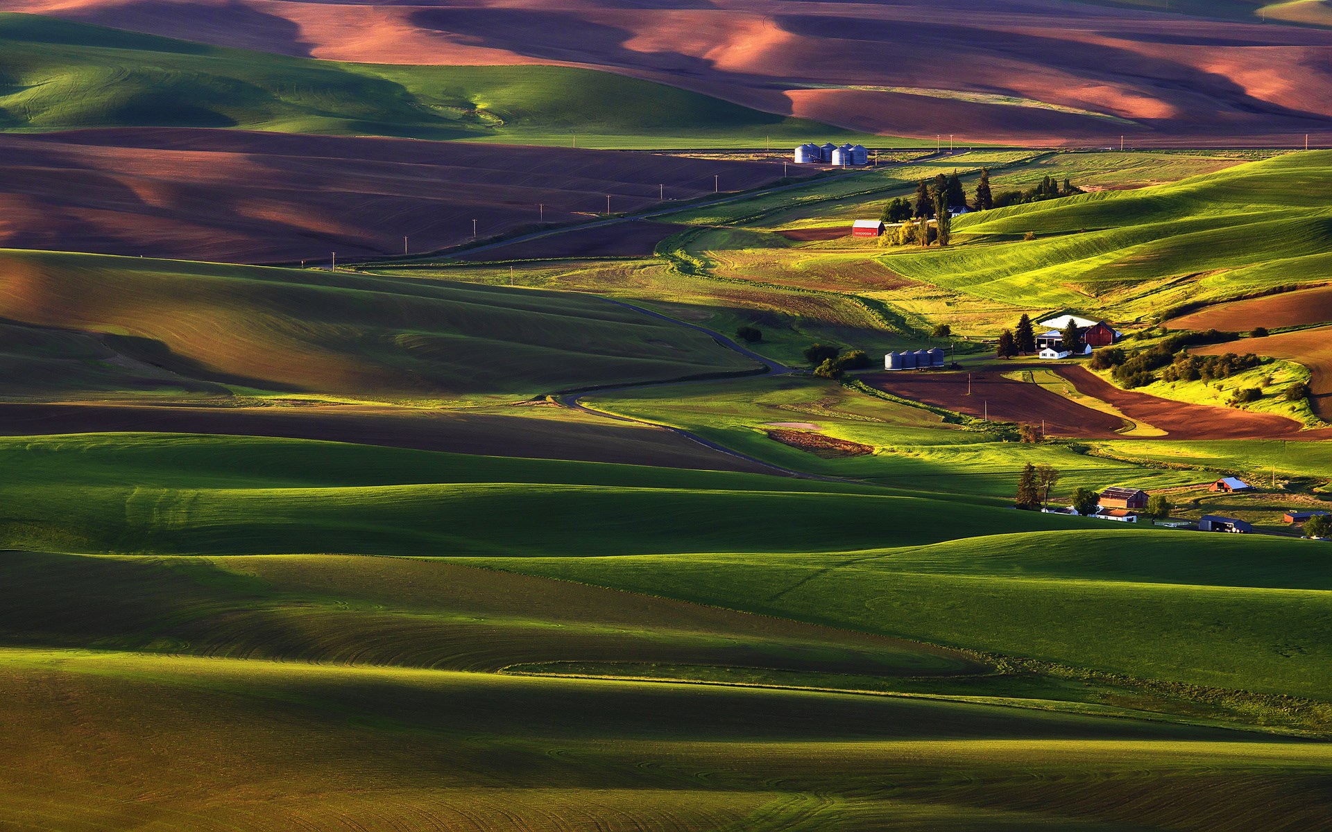 Rolling hills of farmland with buildings HD Wallpaper