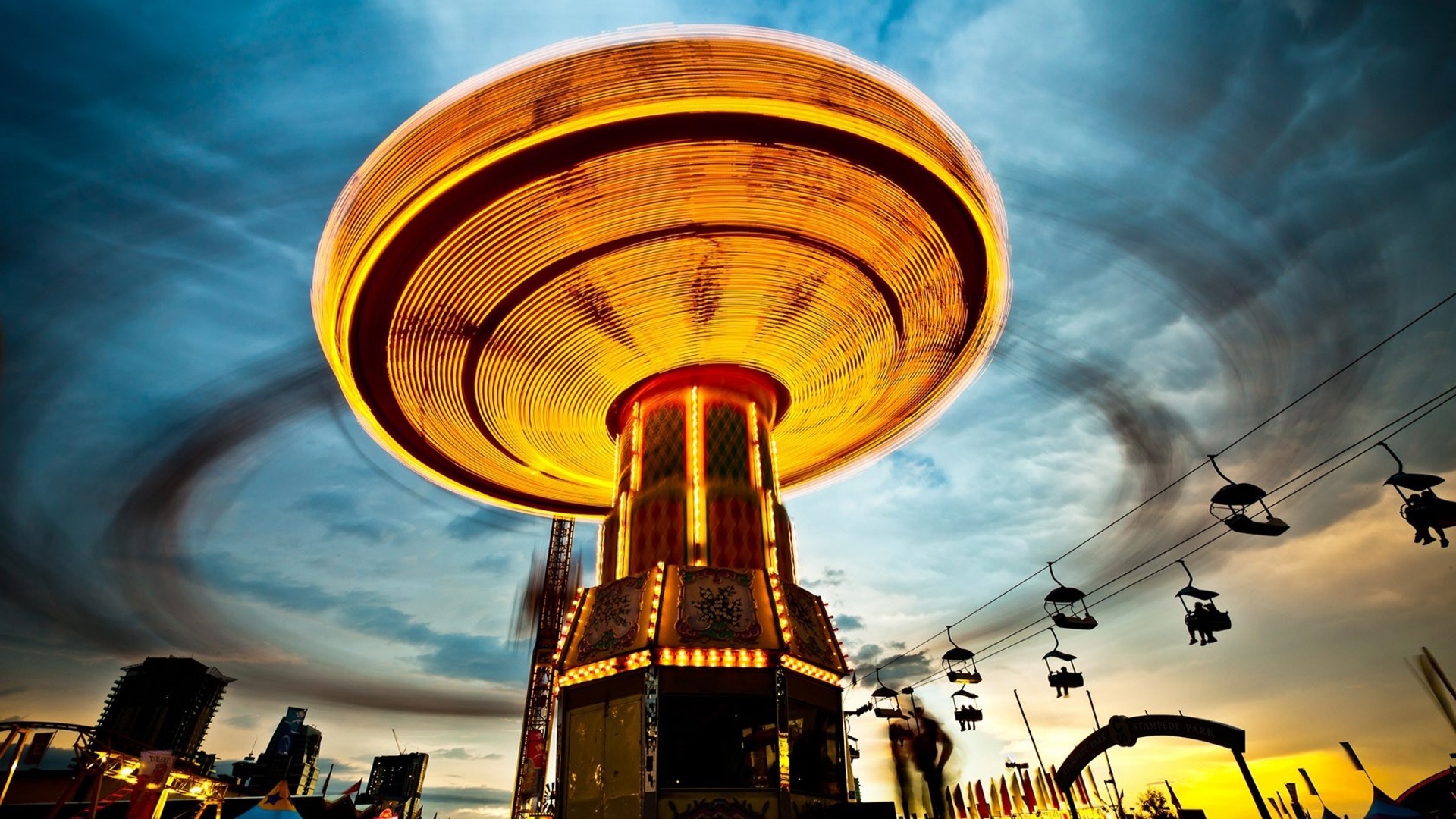 Amusement park ride with motion blur at sunset HD Wallpaper