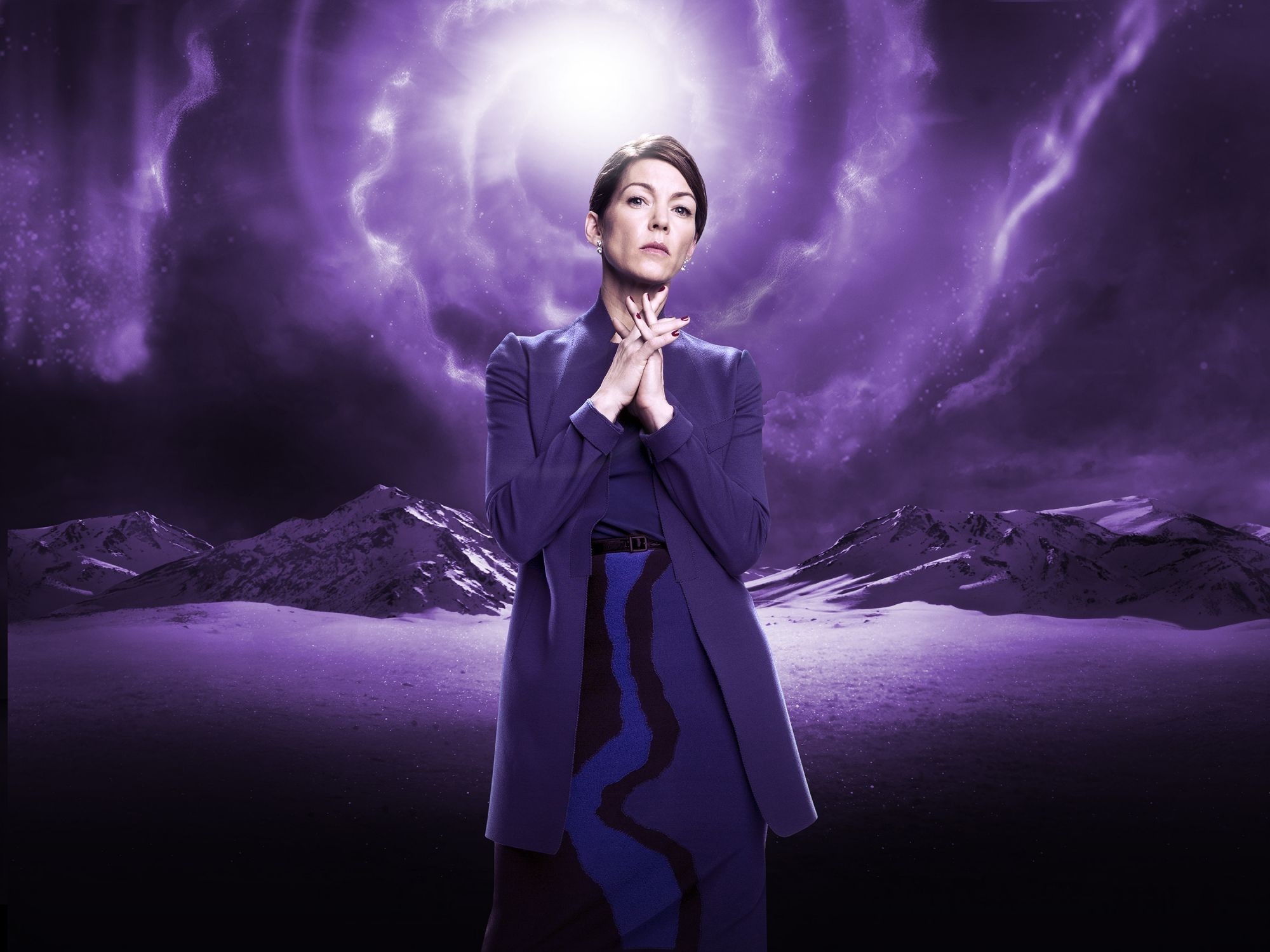 Woman in purple suit in front of purple sky and mountains HD Wallpaper