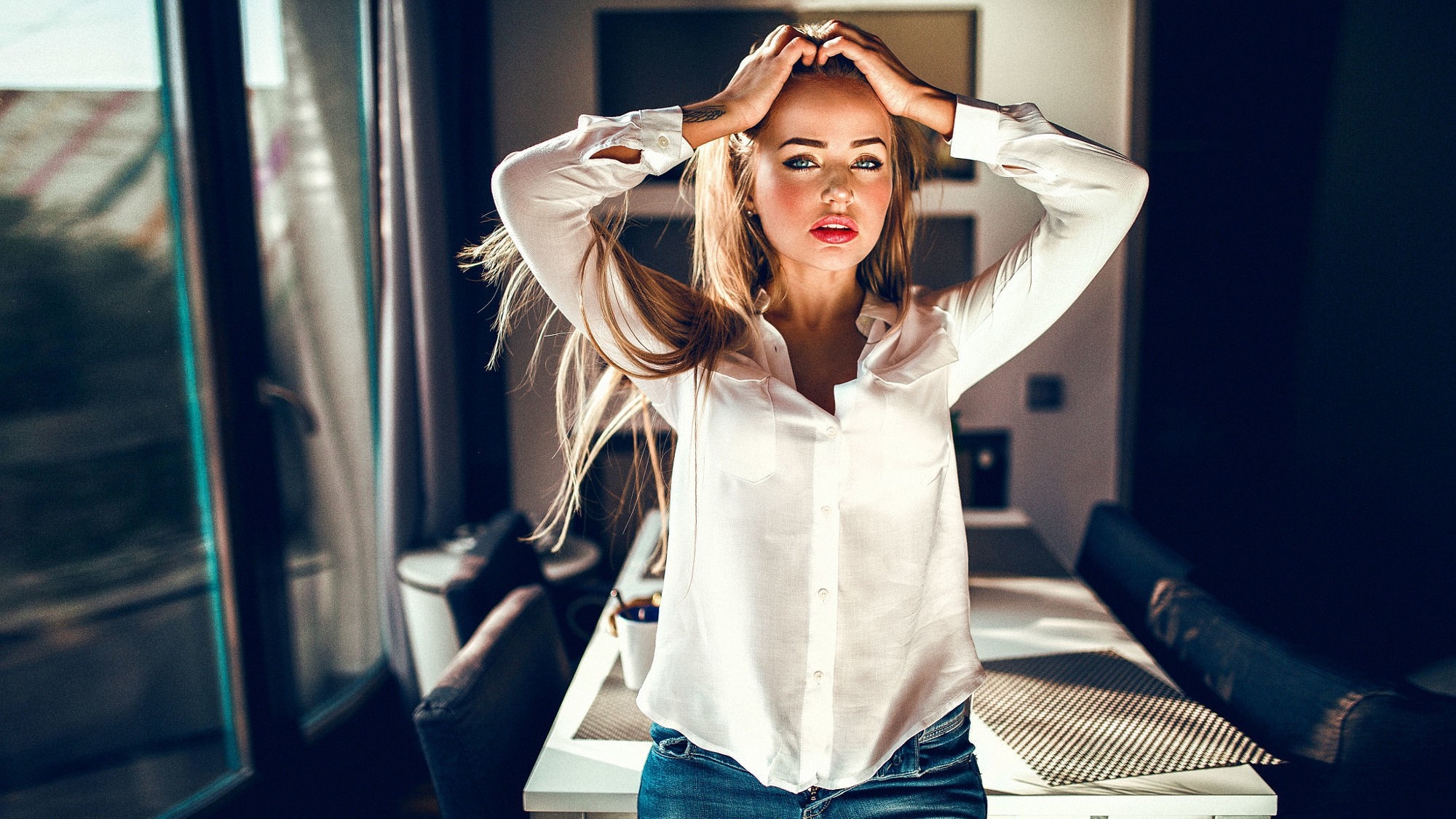 Woman in white shirt and jeans with hands in hair HD Wallpaper