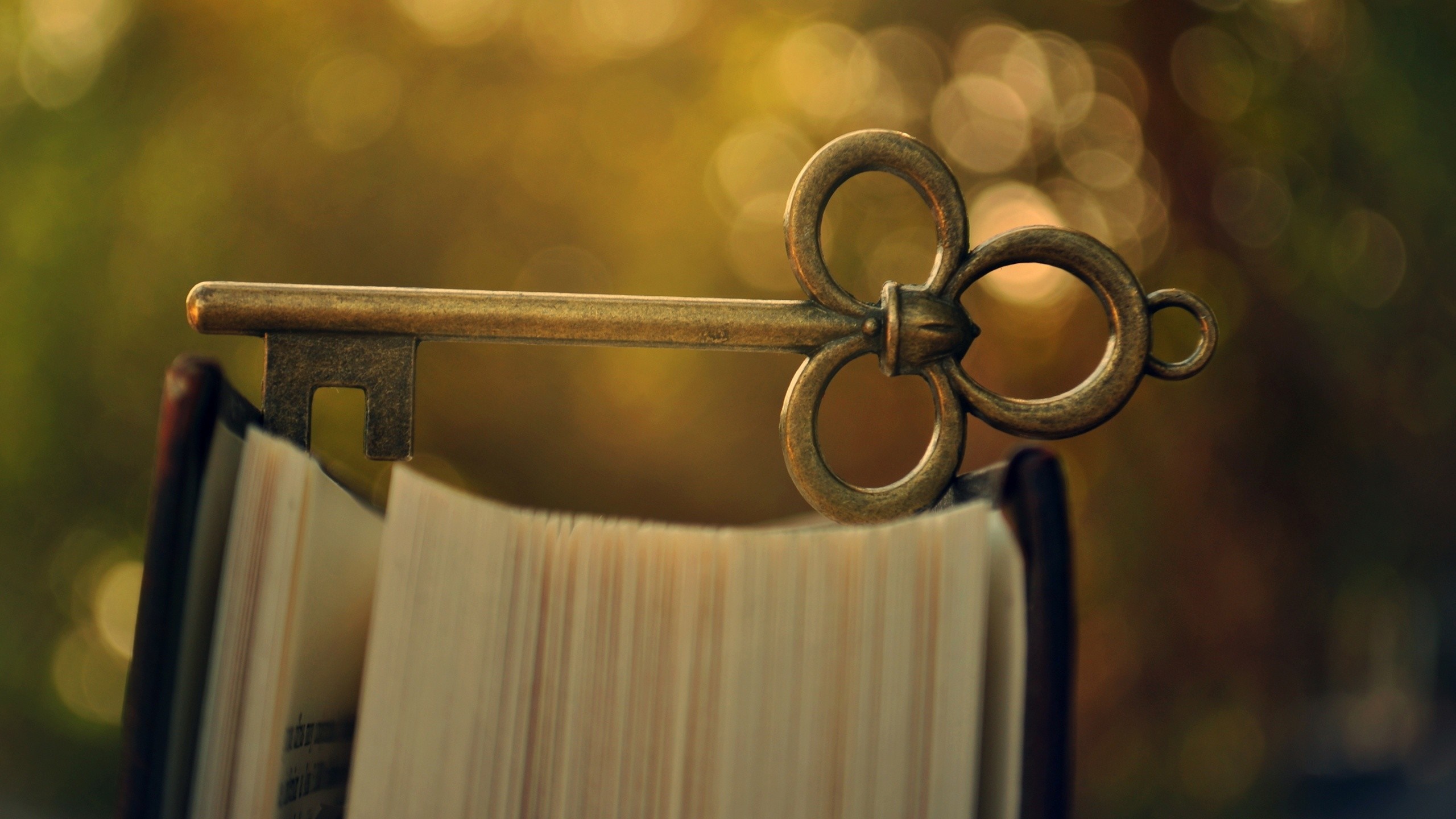 Antique key resting on an open book HD Wallpaper