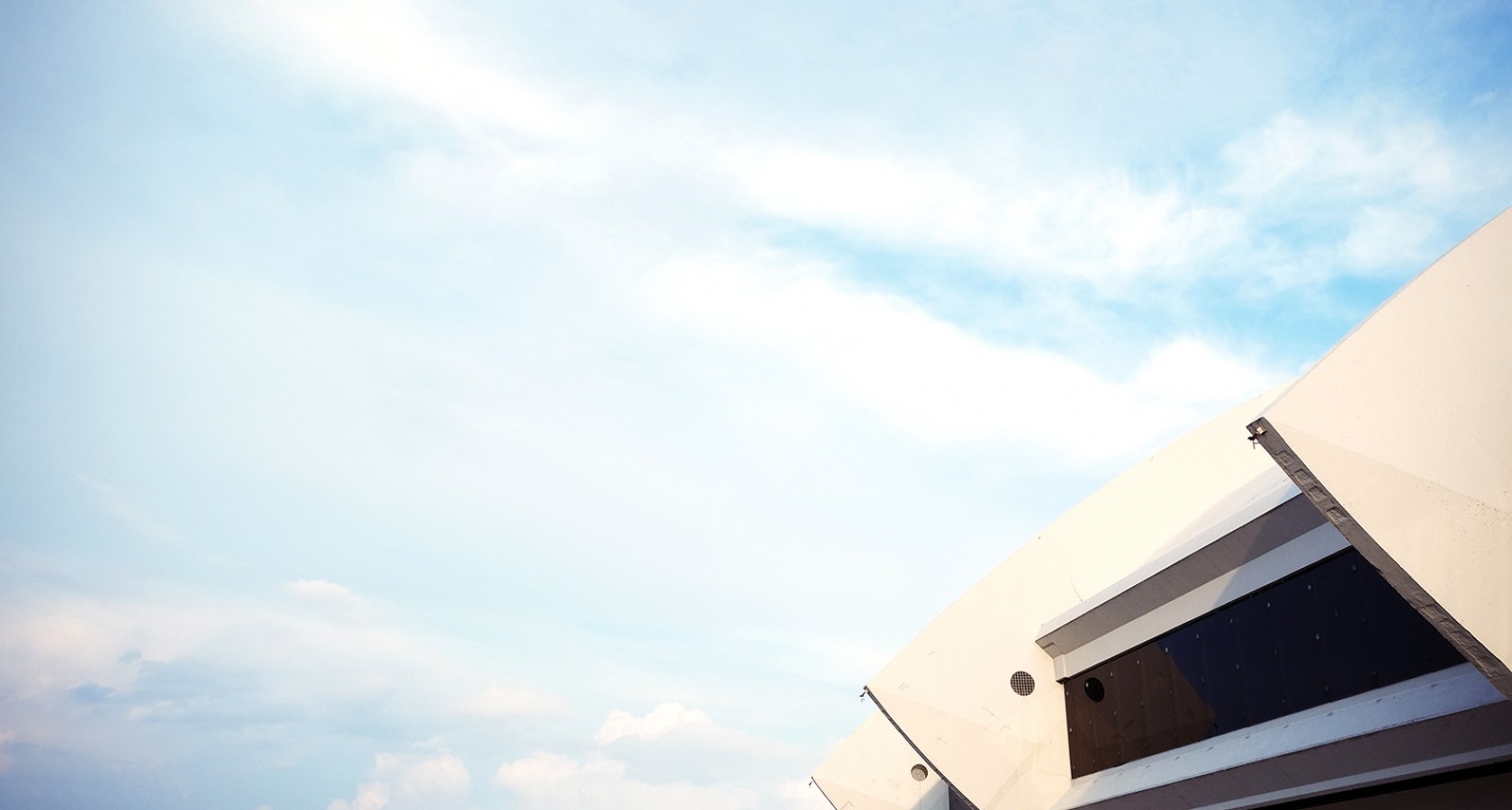 Modern architecture against a cloudy blue sky HD Wallpaper