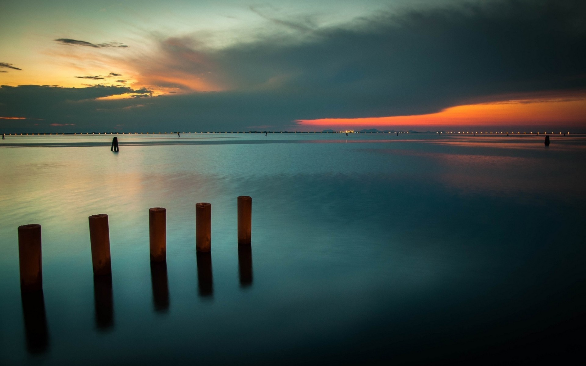 Sunset over the sea with wooden posts HD Wallpaper