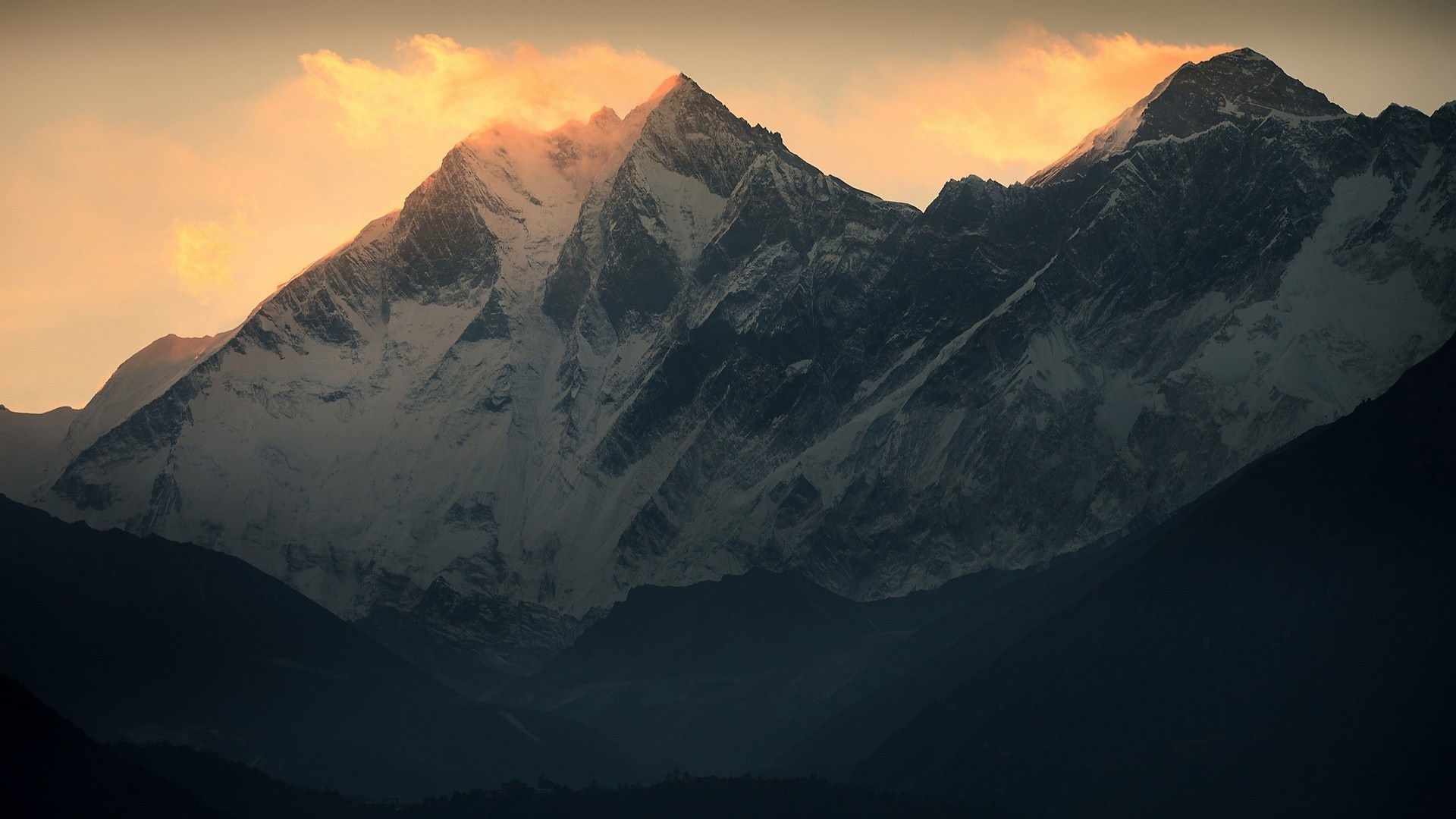 Snow-capped mountains at sunrise with orange clouds HD Wallpaper