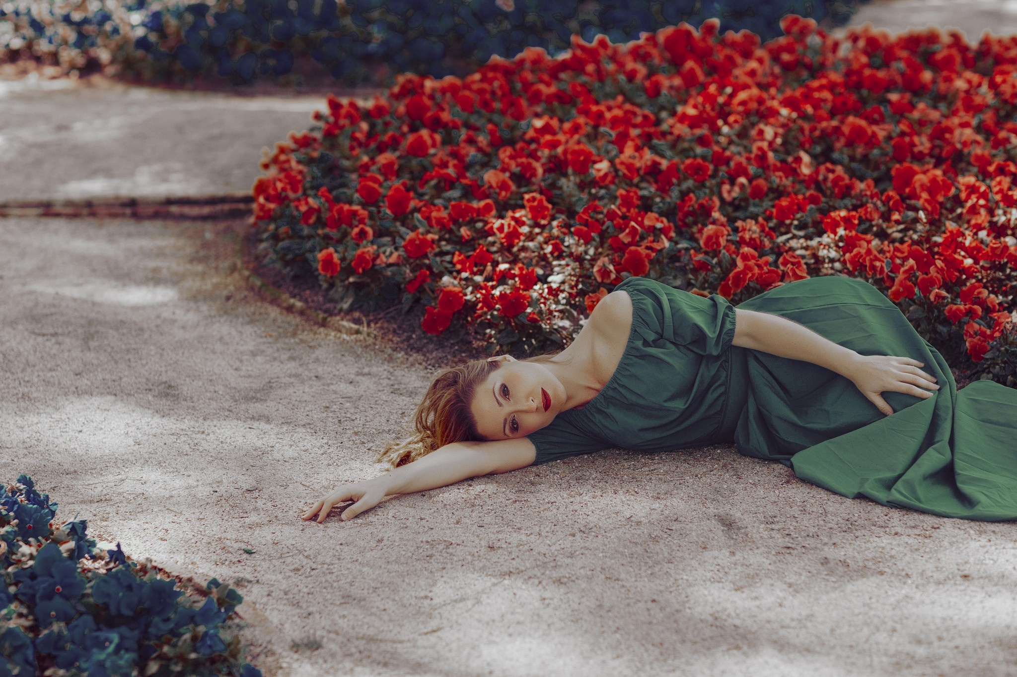 Woman in green dress lying in a garden with red flowers HD Wallpaper