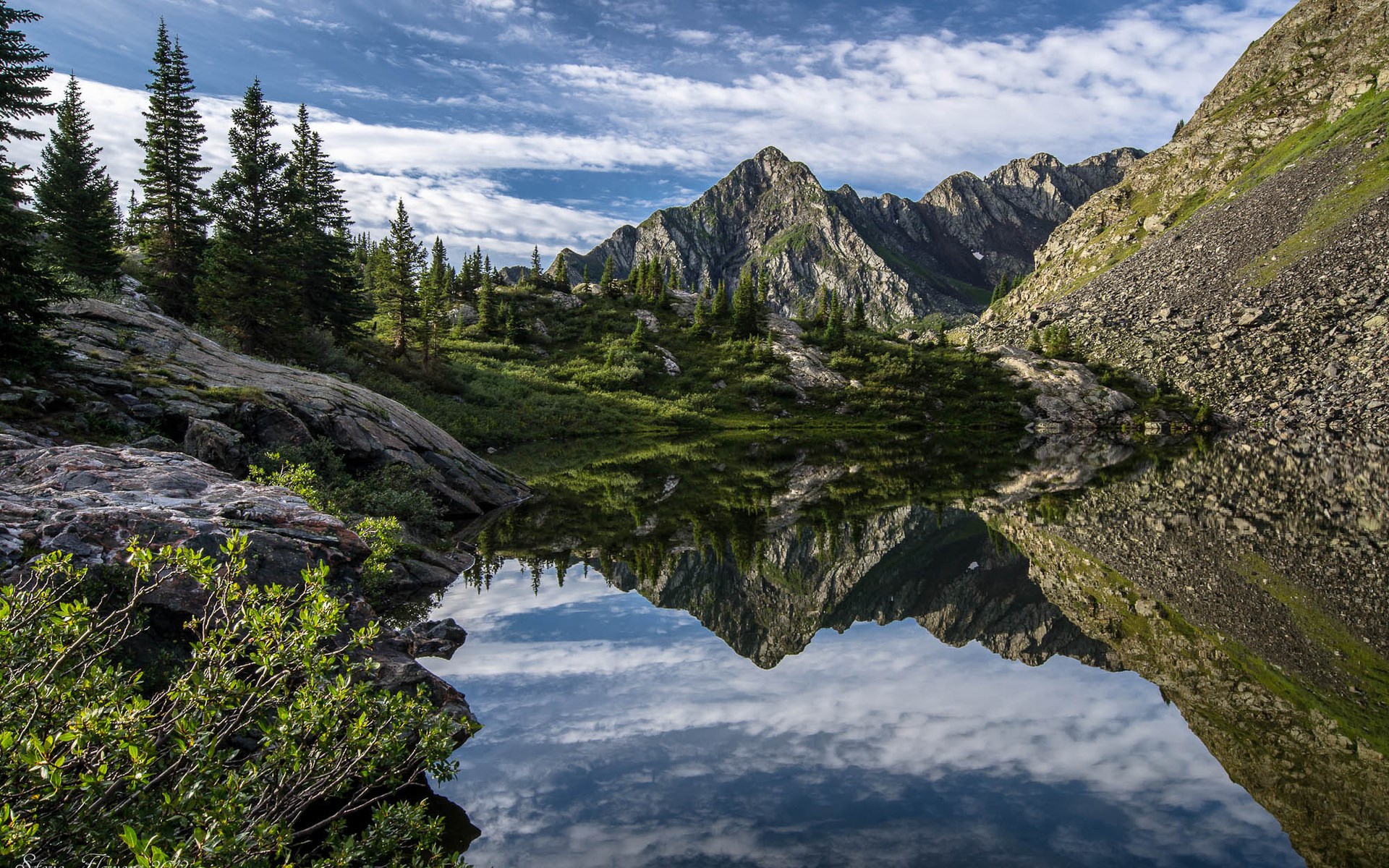 Mountain lake reflection with trees and rocky slopes HD Wallpaper