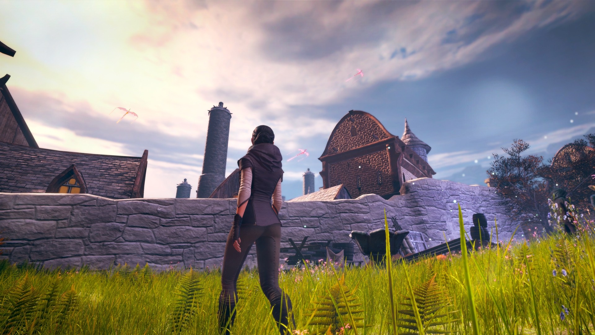 A woman stands in a field overlooking a village HD Wallpaper