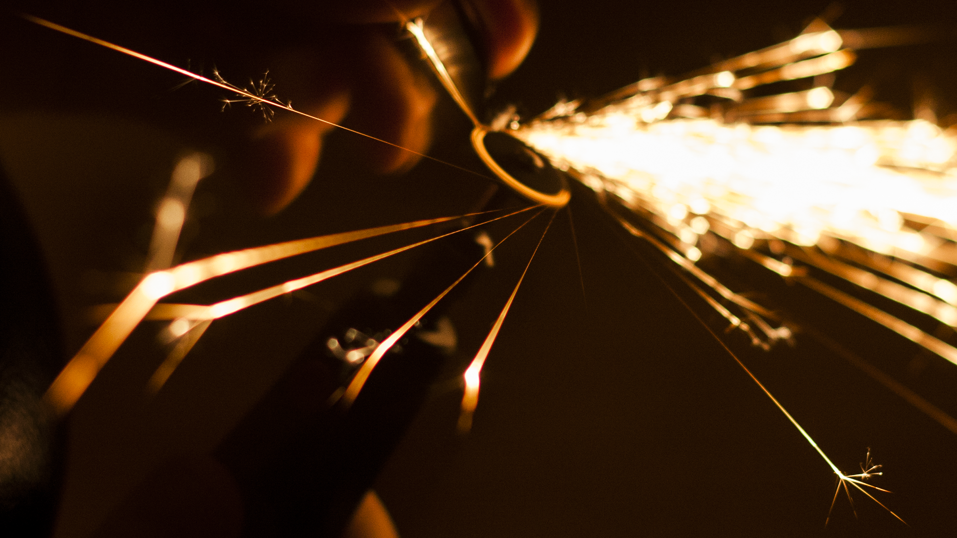 Close-up of sparks flying from a sparkler HD Wallpaper