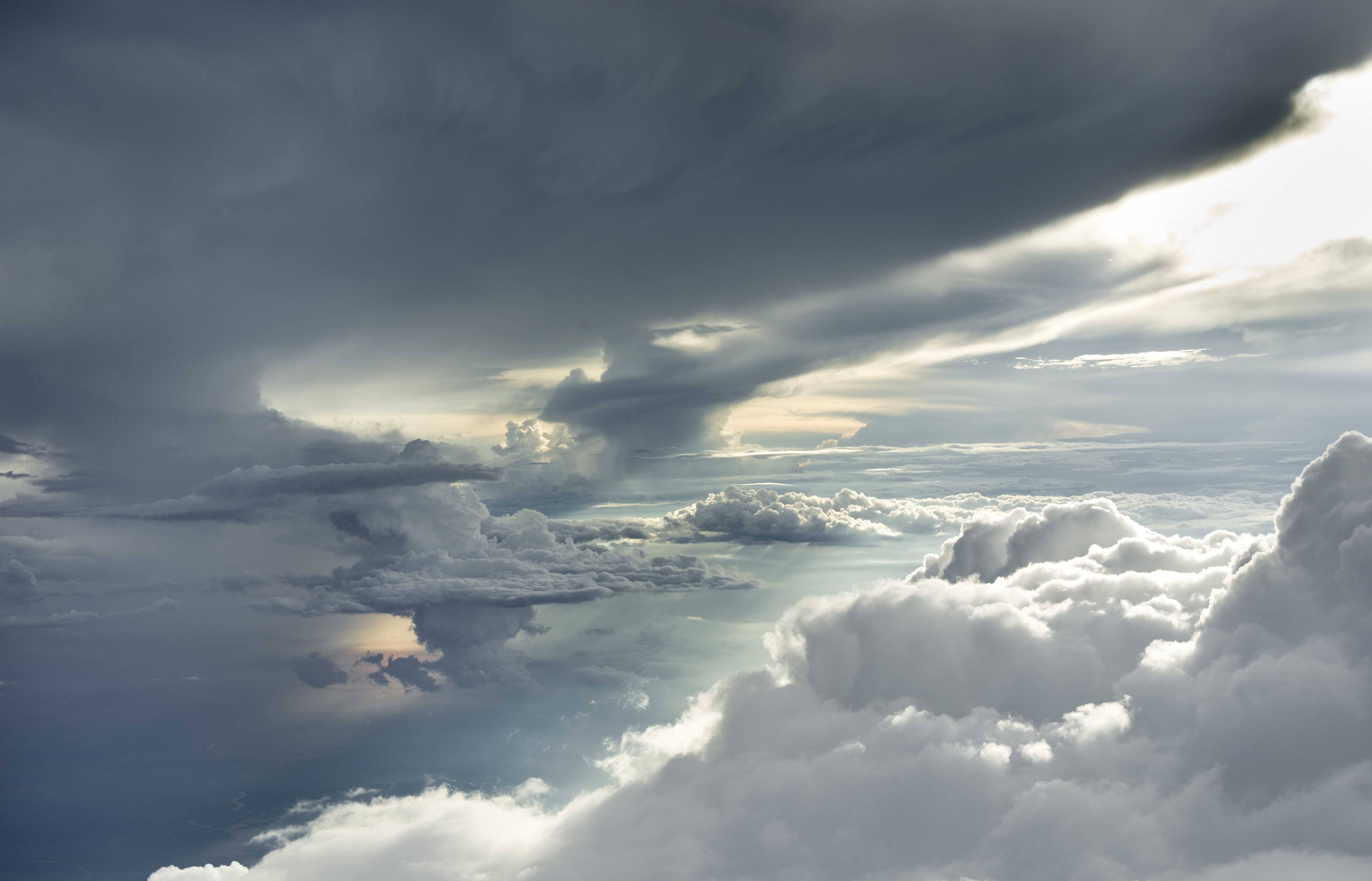 Dramatic storm clouds illuminated by sunlight from above HD Wallpaper