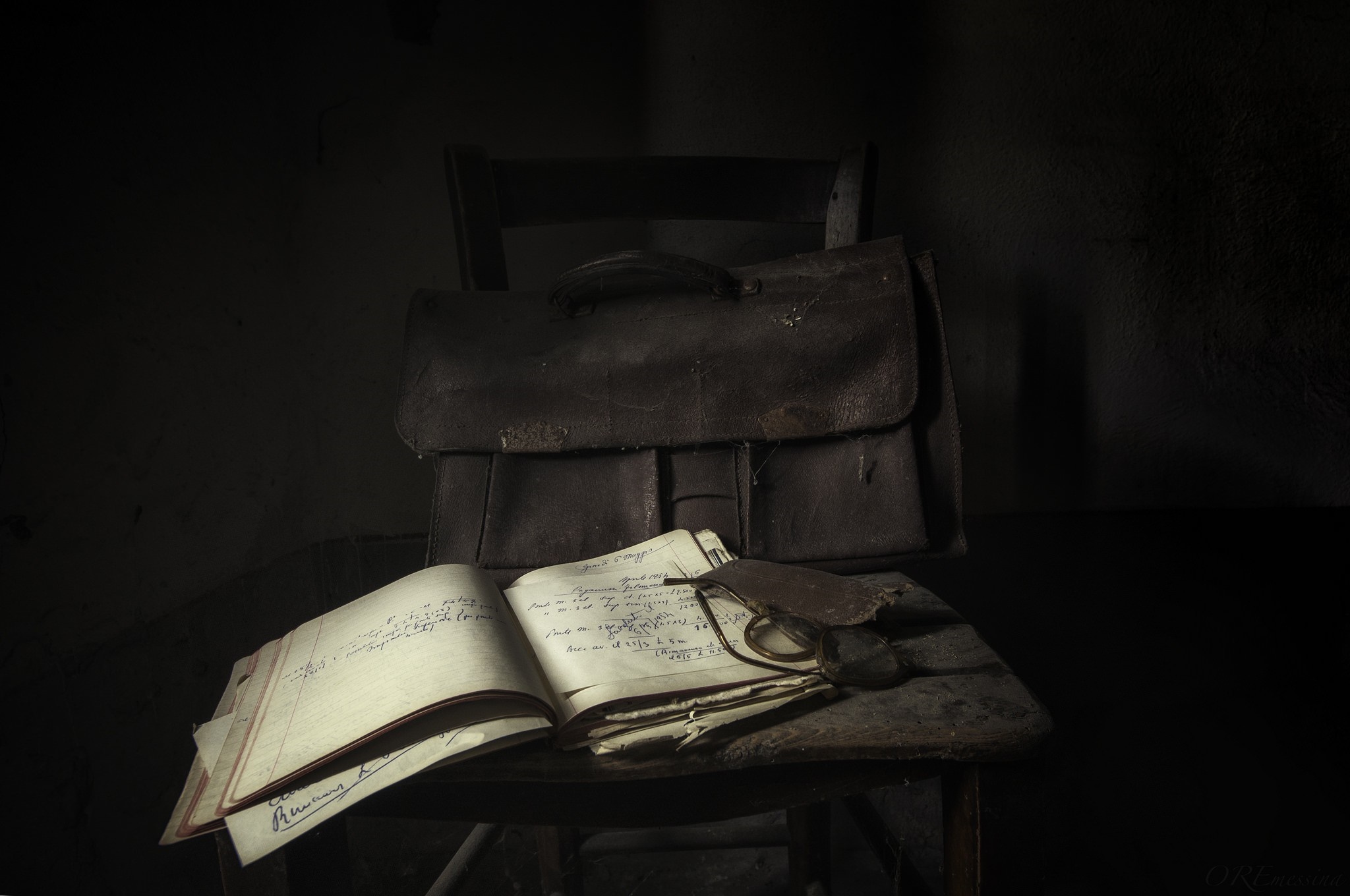 Old leather briefcase and open notebook on a chair HD Wallpaper
