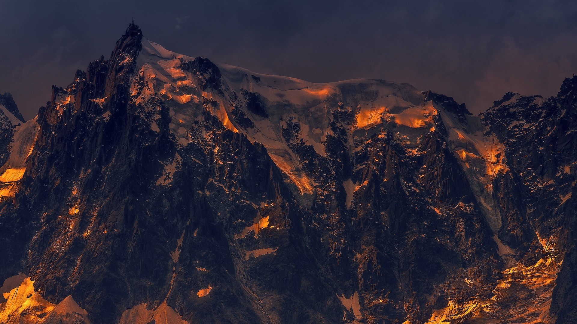 Mountain range illuminated by sunset light HD Wallpaper