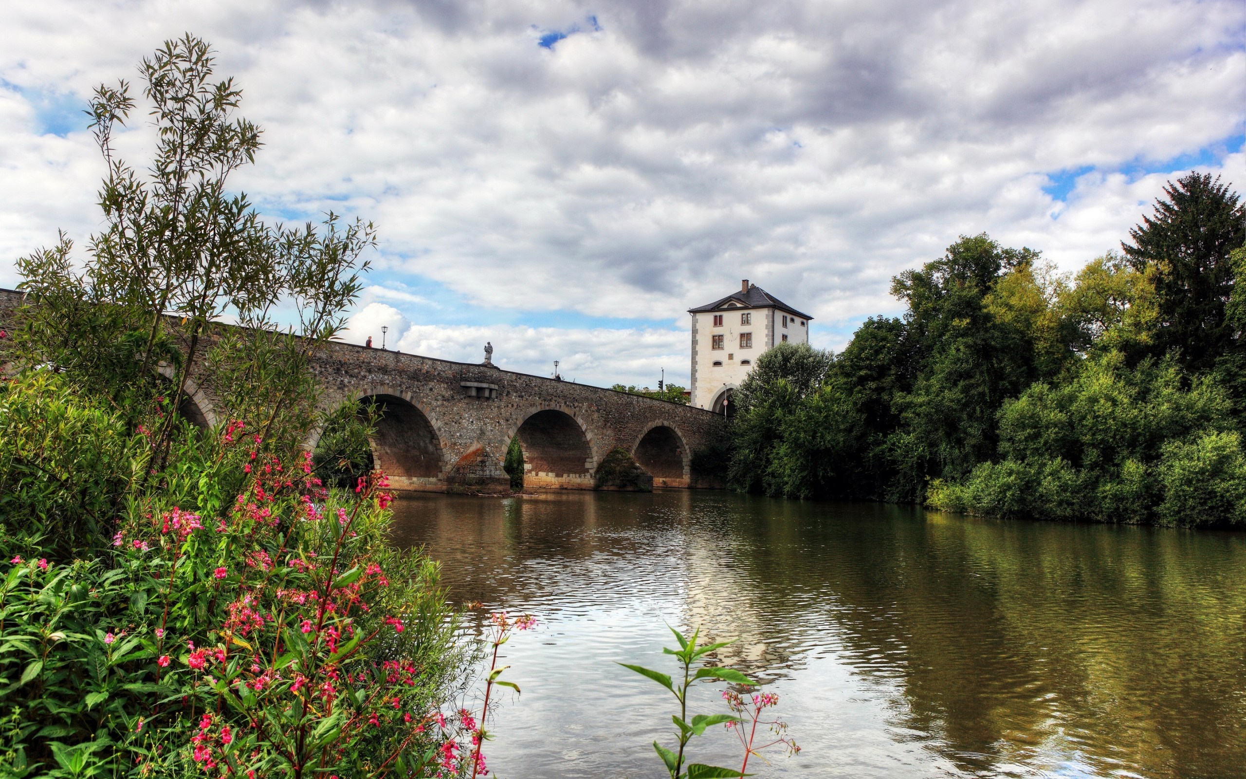 Stone bridge over a river with a tower and trees HD Wallpaper