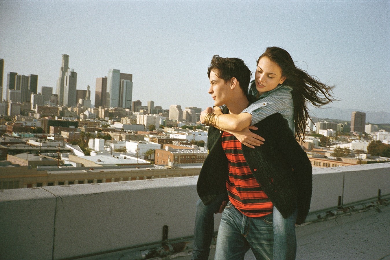 Couple on a rooftop overlooking a city HD Wallpaper