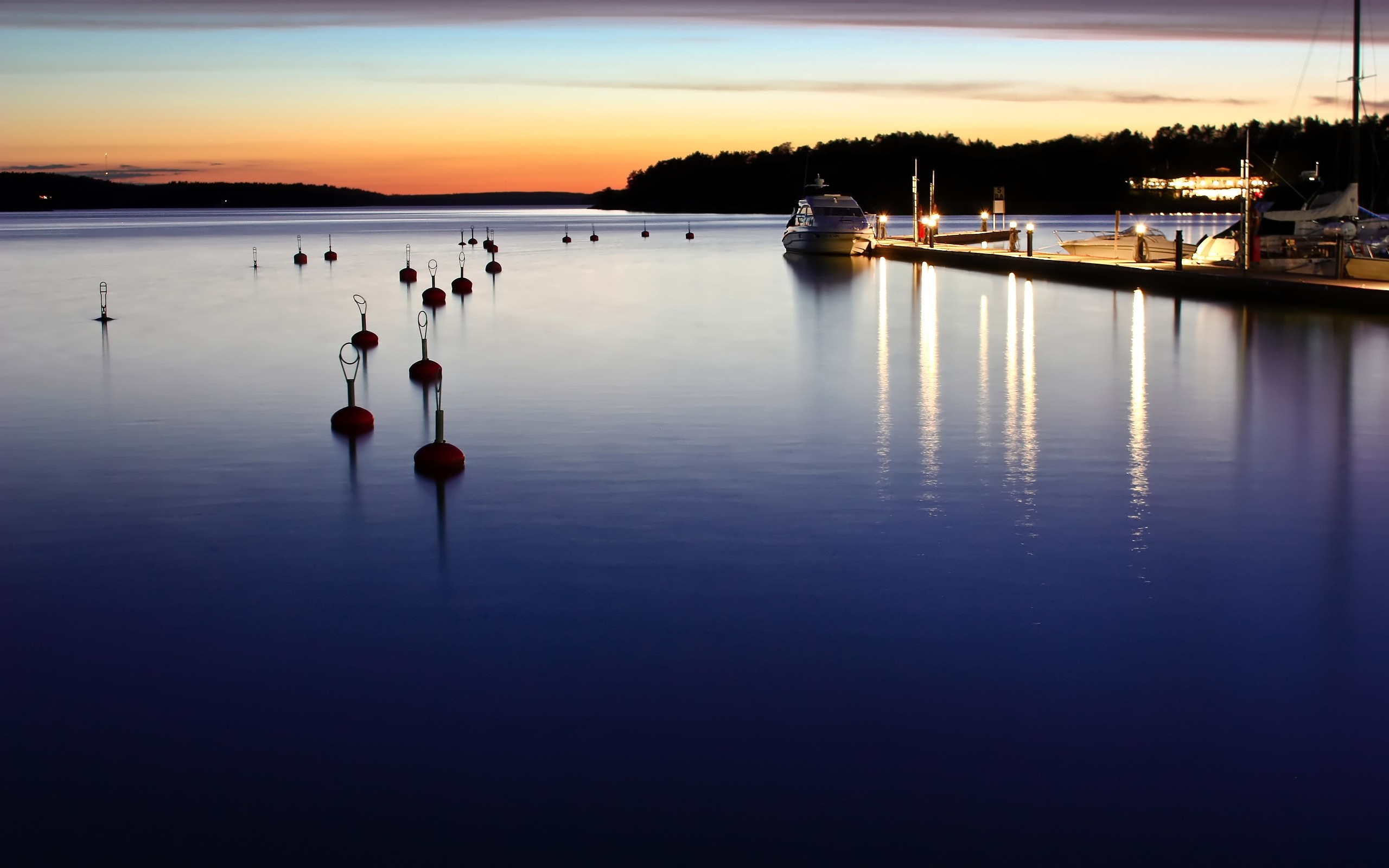 Boats and buoys on a lake at sunset HD Wallpaper