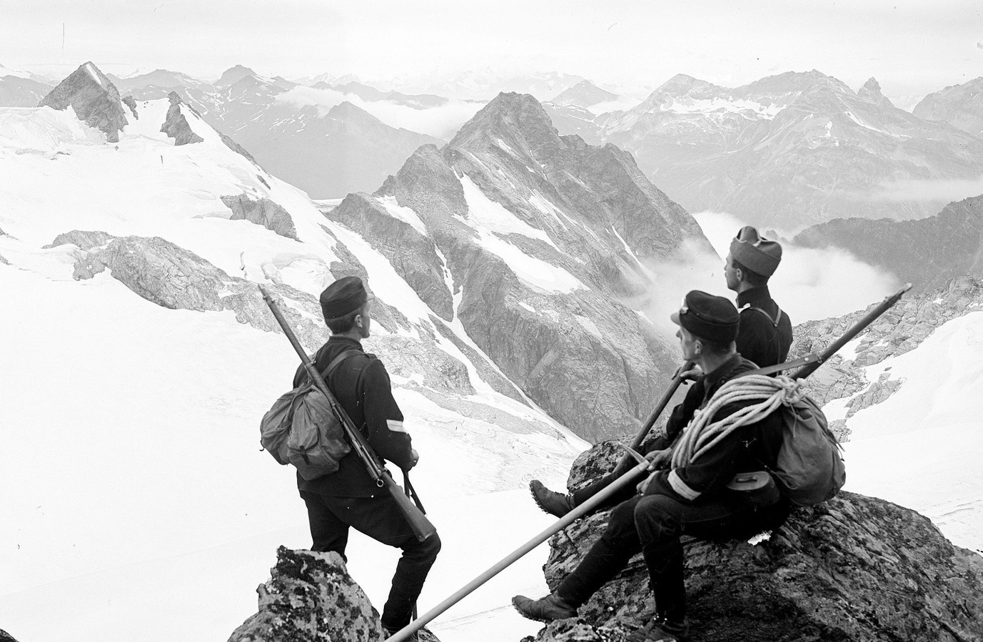 Soldiers with rifles and backpacks in the Alps HD Wallpaper