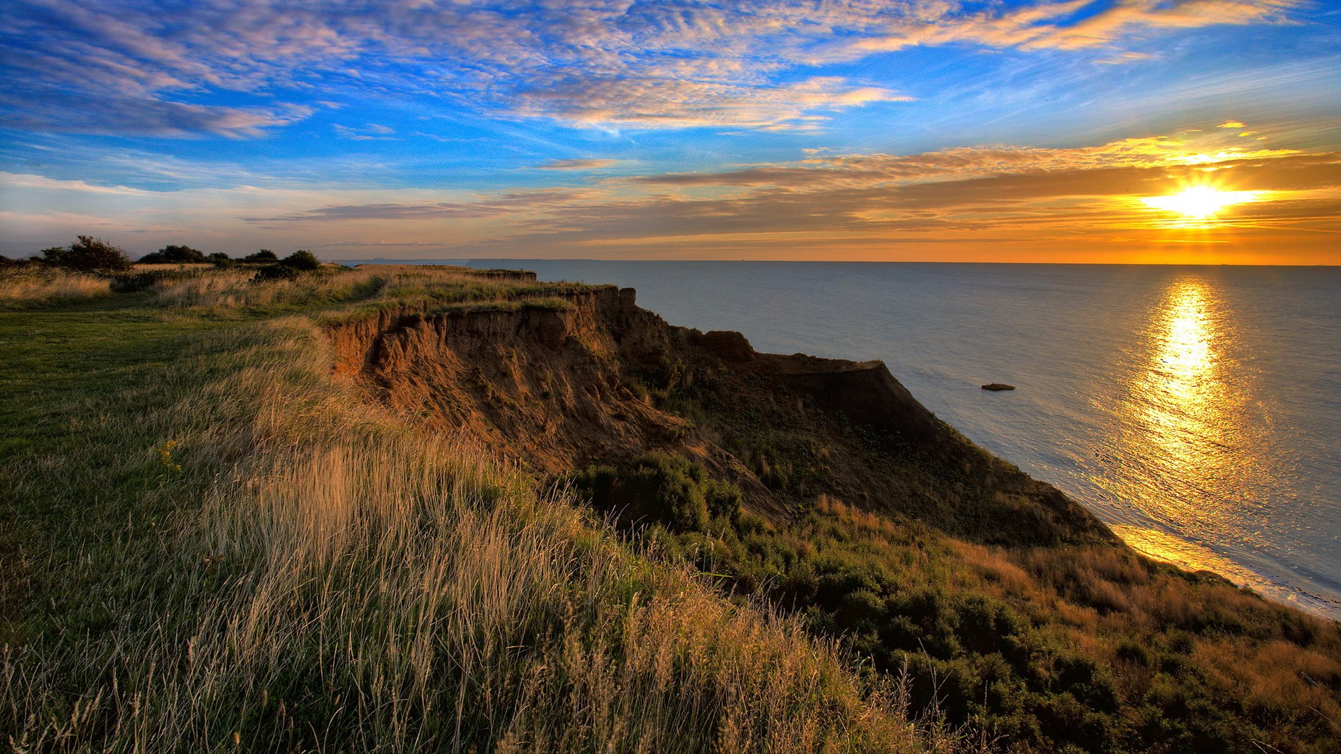 Sunset over a cliff overlooking the ocean HD Wallpaper