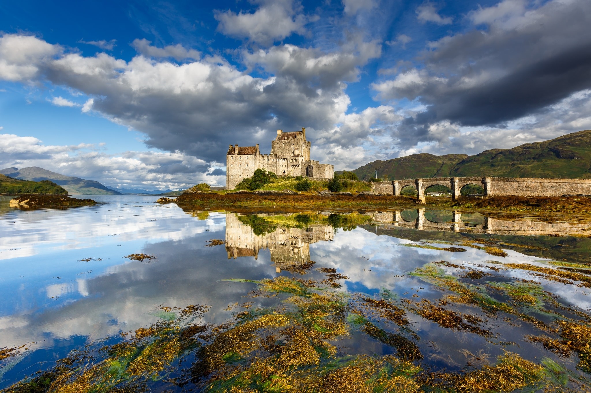 Eilean Donan Castle reflected in water with bridge and hills HD Wallpaper