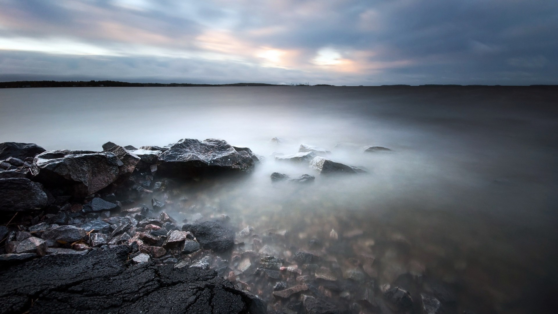 Long exposure of rocky shore and calm water HD Wallpaper