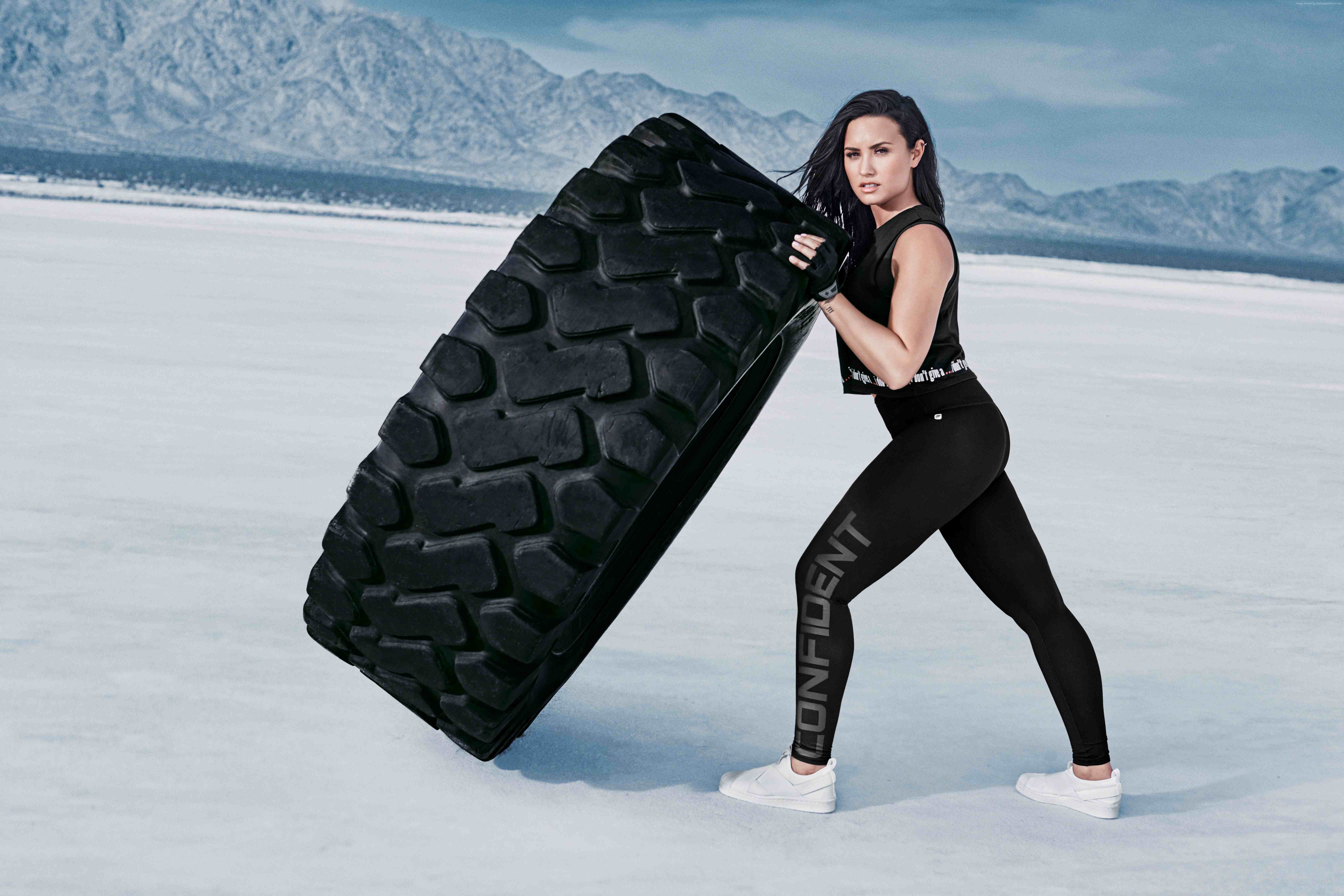 Demi Lovato lifting a large tire HD Wallpaper