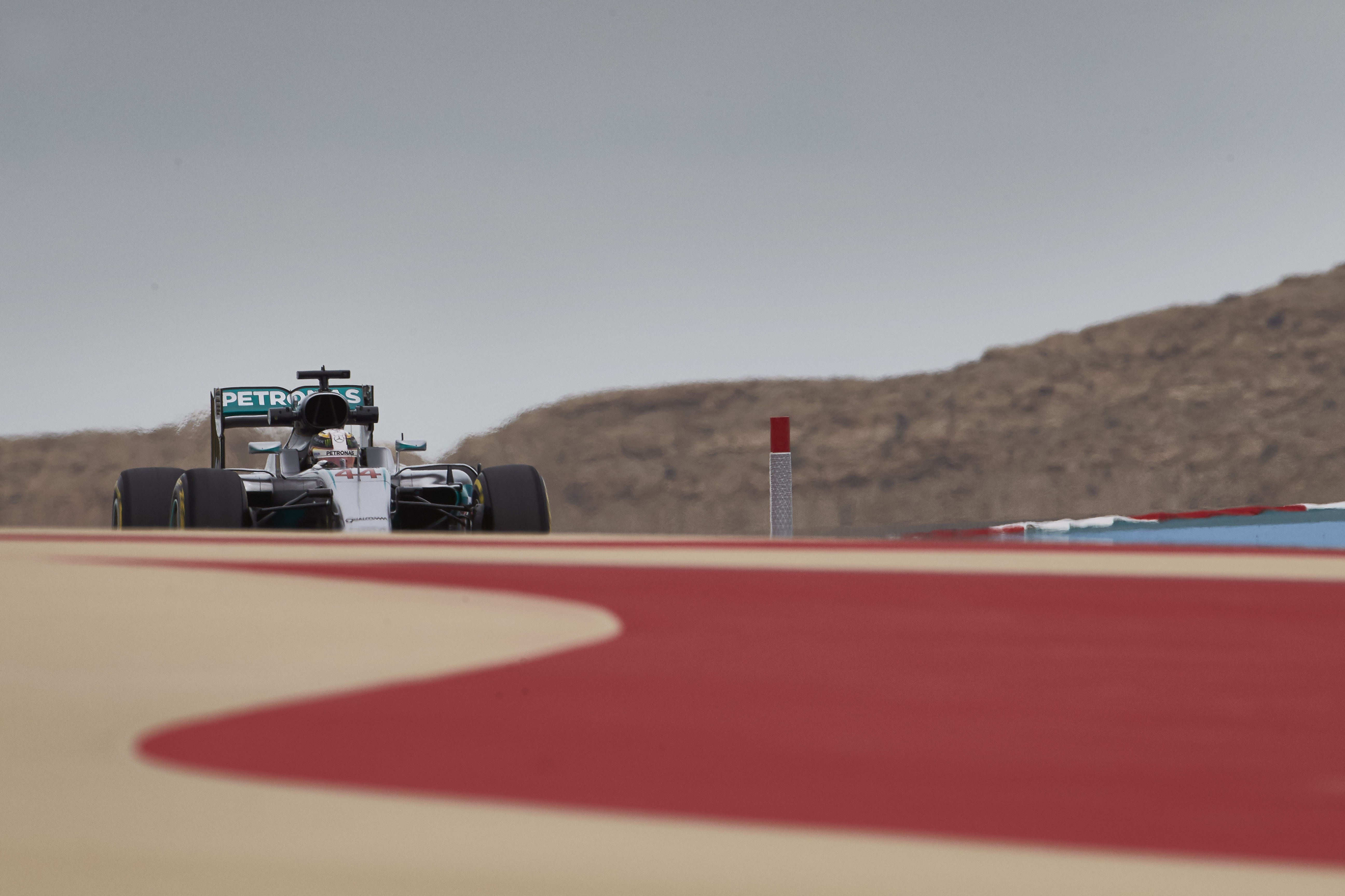 Lewis Hamilton driving a Mercedes F1 car on a race track HD Wallpaper