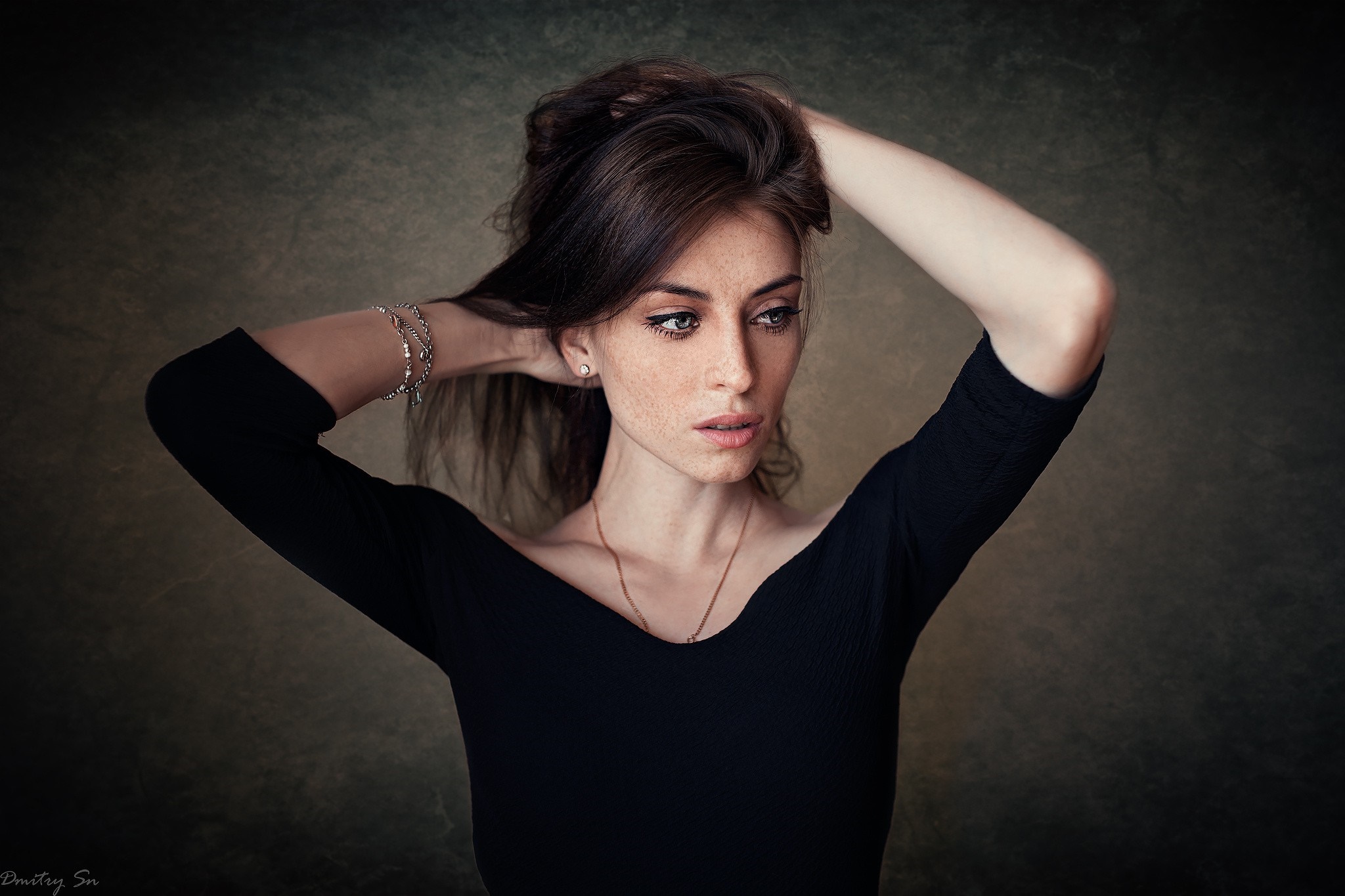 Woman with hands in brown hair, freckles, and blue eyes HD Wallpaper