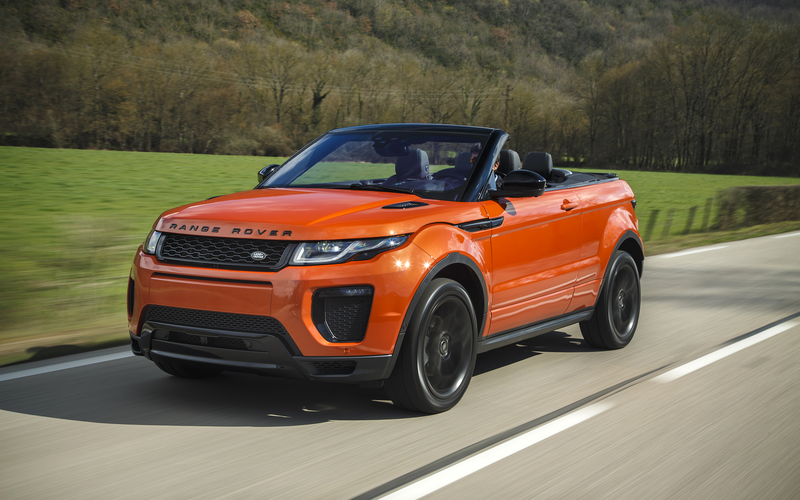 Orange Range Rover Evoque Convertible driving on a road HD Wallpaper