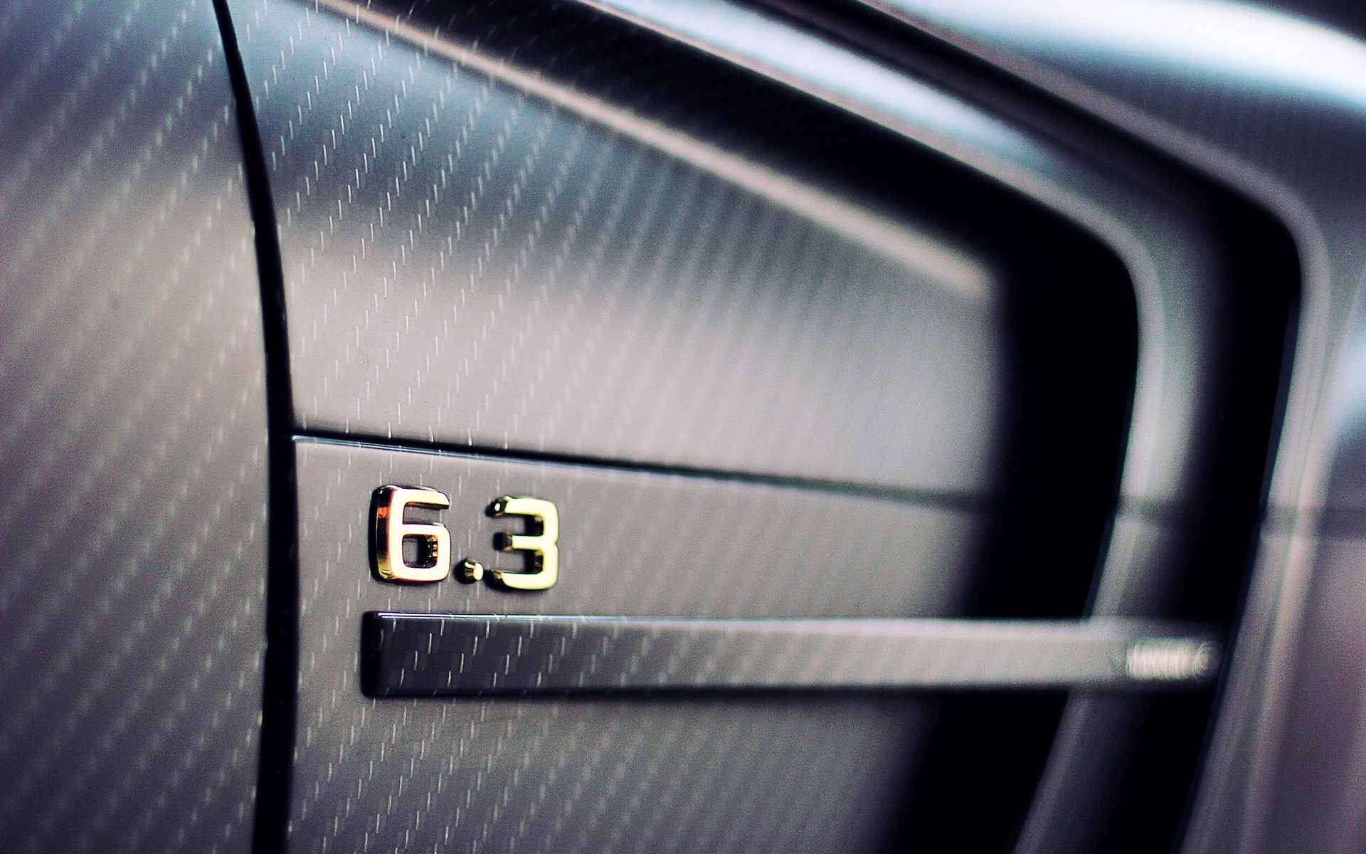 Mercedes-Benz C63 AMG 6.3 badge on carbon fiber HD Wallpaper