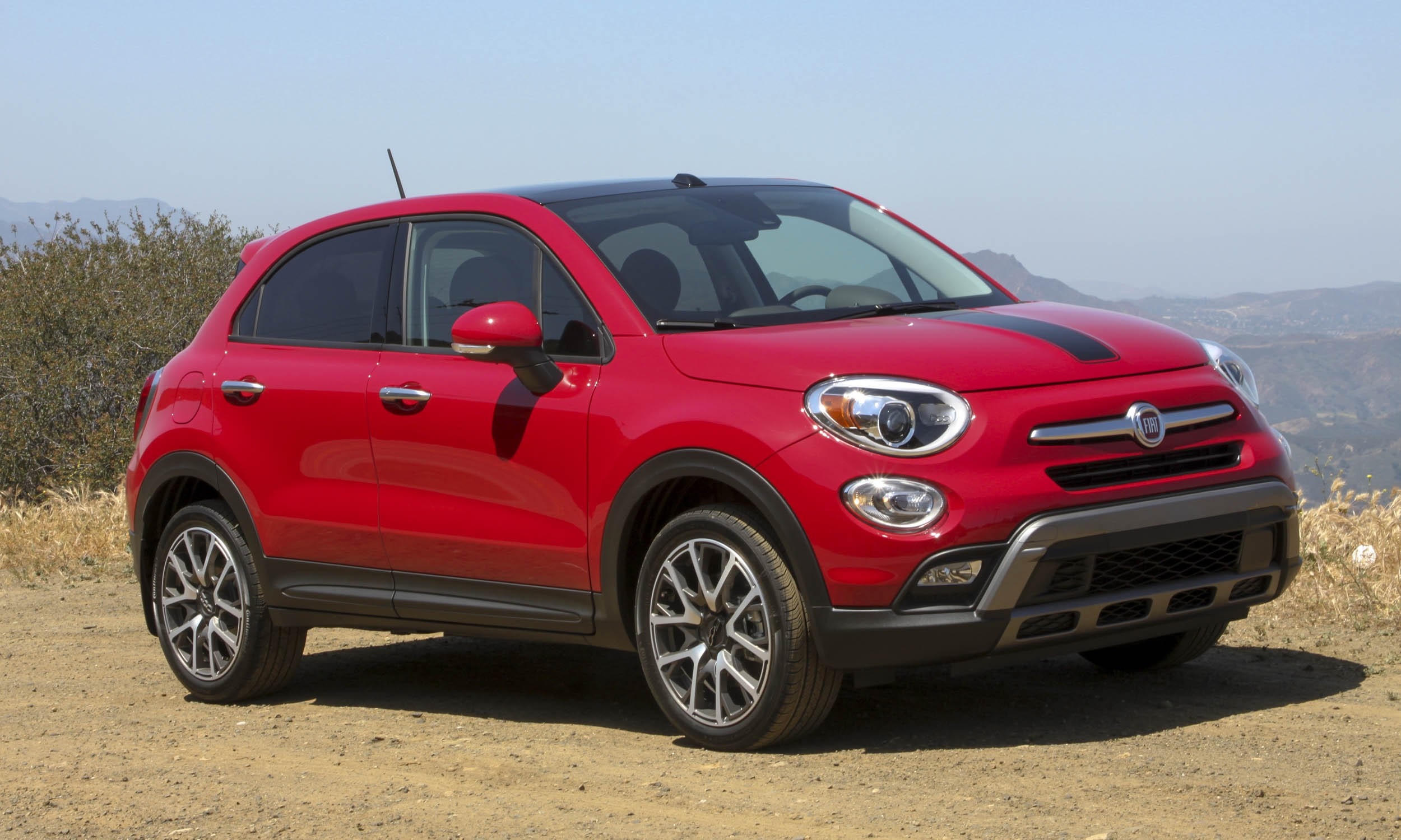 Red Fiat 500X parked on a dirt road with hills in the background HD Wallpaper
