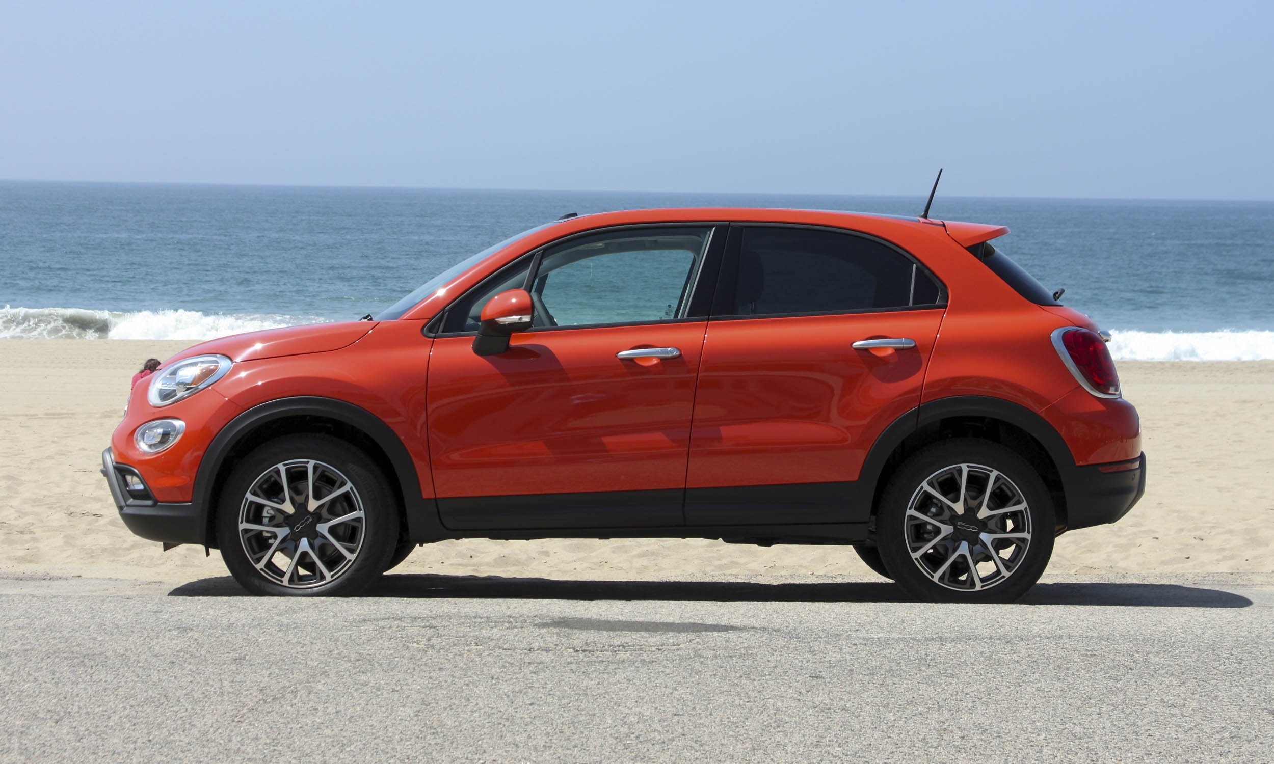 Orange Fiat 500X parked on the beach HD Wallpaper