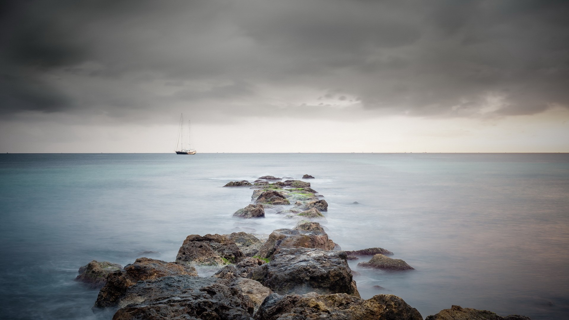 Sailboat on the ocean with a rocky path HD Wallpaper