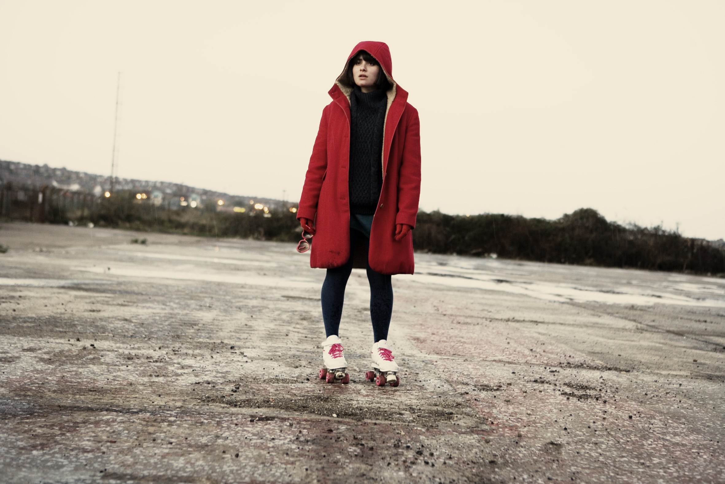 Girl in red coat and roller skates HD Wallpaper