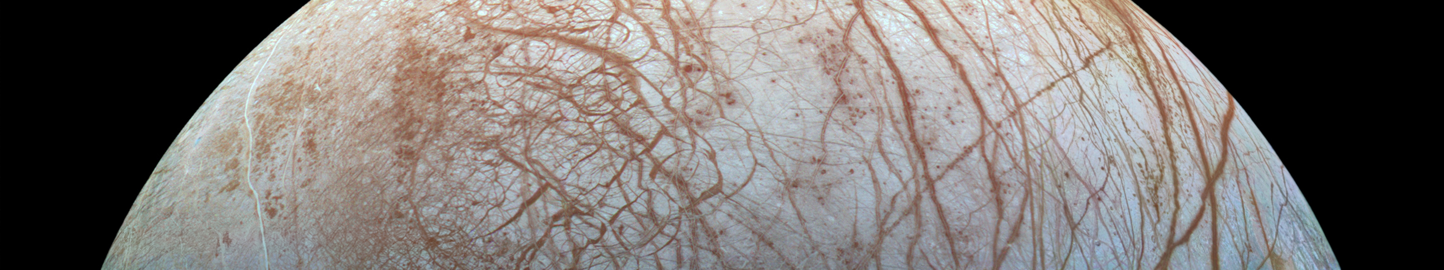 Europa's icy surface with reddish-brown streaks HD Wallpaper