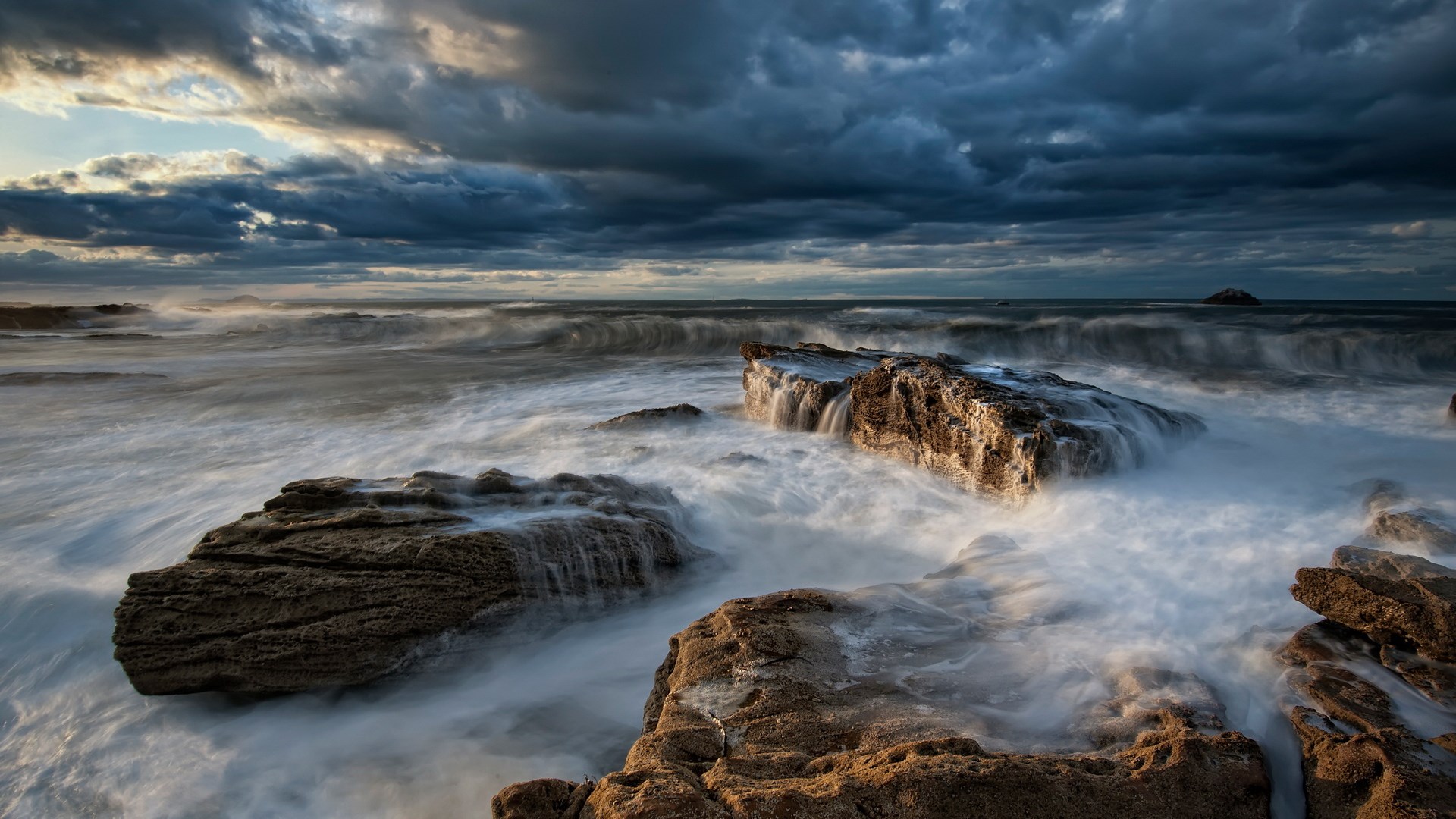 Waves crashing on rocks under stormy clouds HD Wallpaper