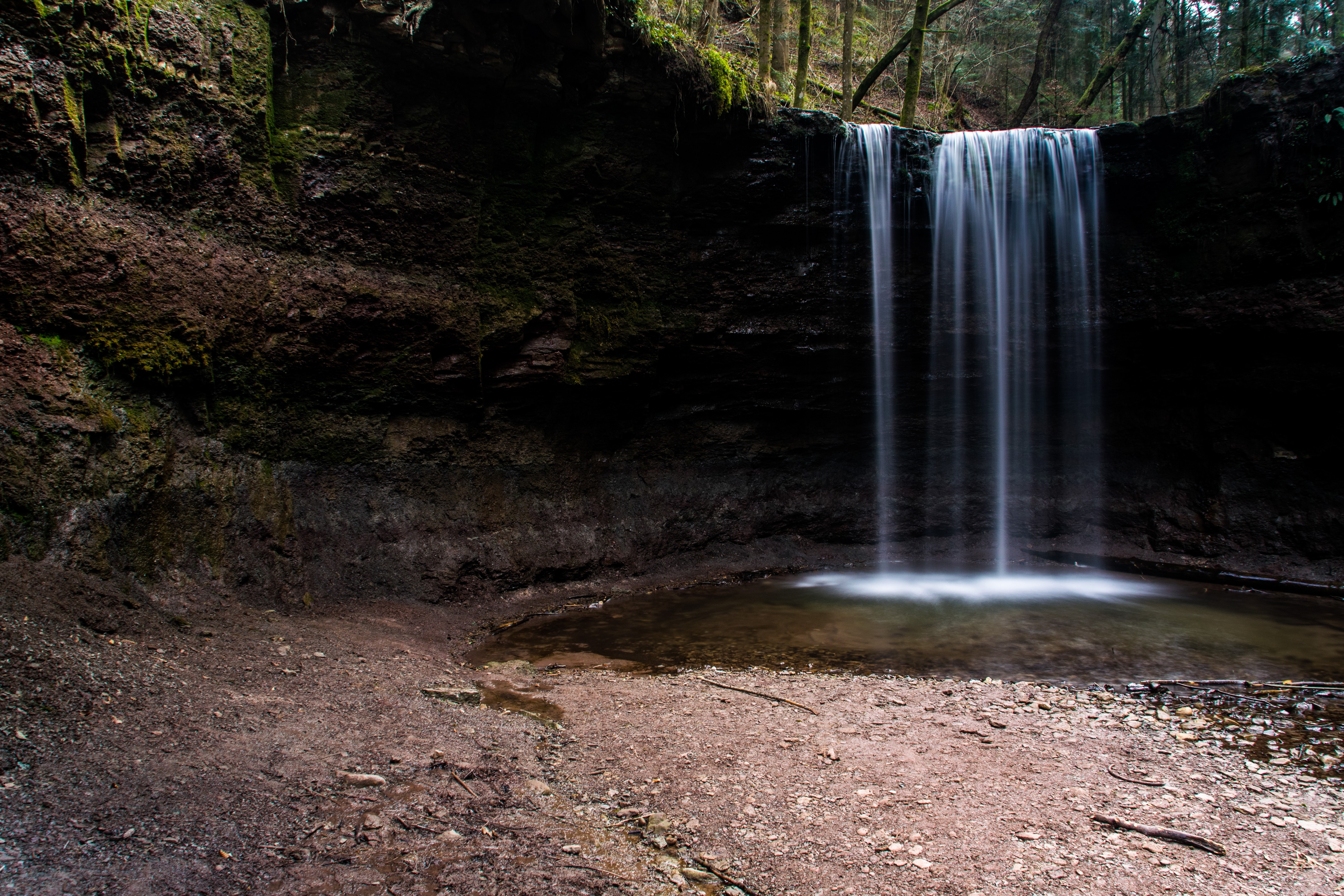Waterfall in a dark forest with long exposure HD Wallpaper