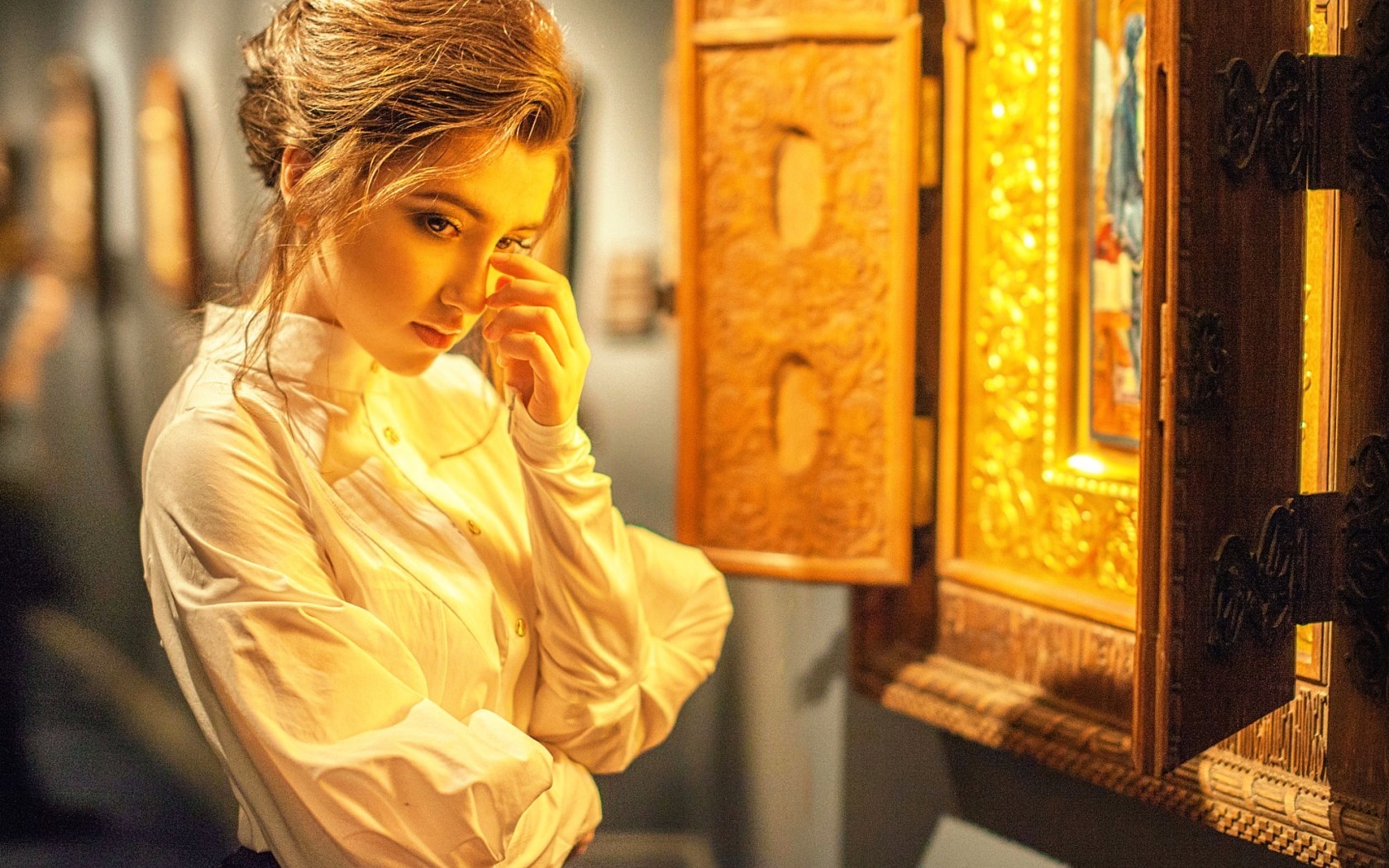 Woman in a white blouse looking at an ornate display HD Wallpaper
