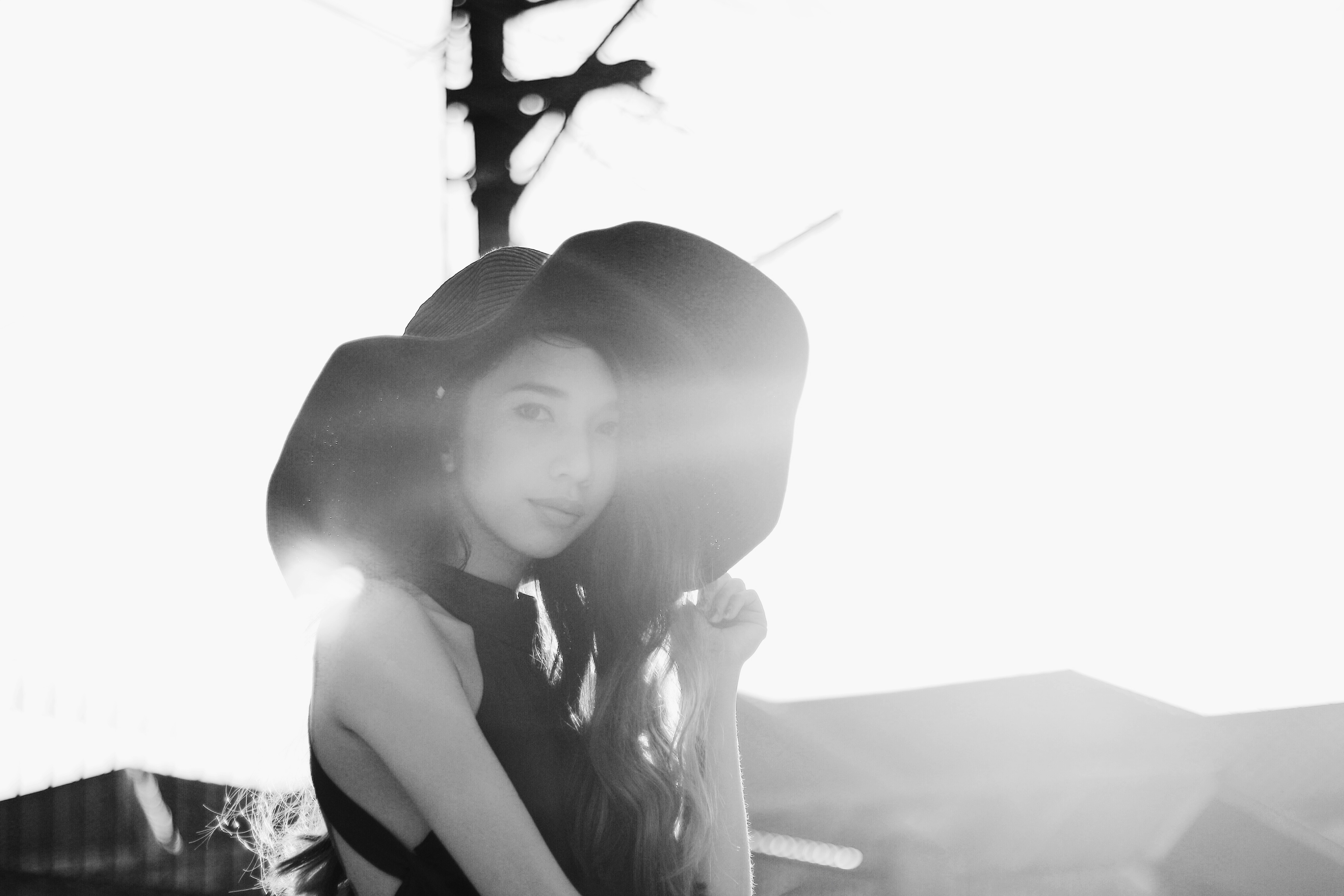 Woman in a wide-brimmed hat with lens flare HD Wallpaper