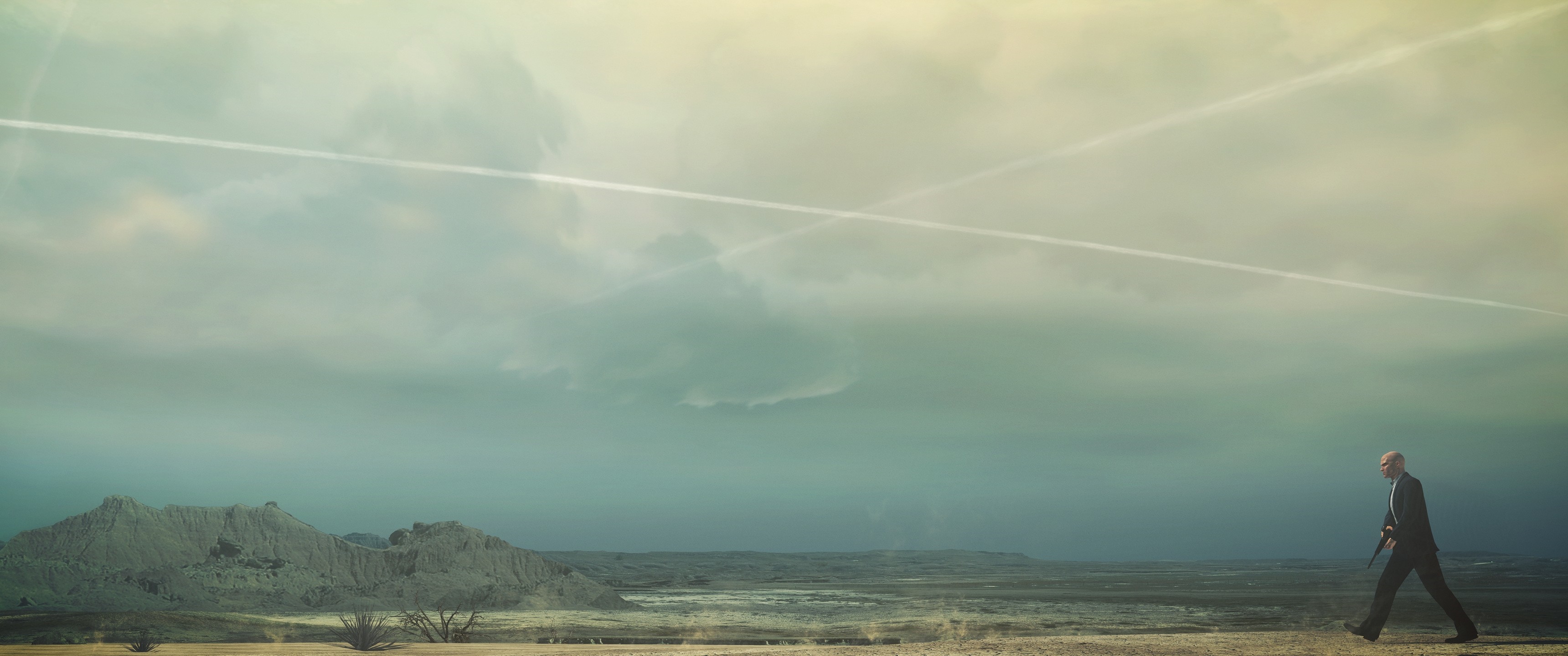 Agent 47 from Hitman walking in a desert landscape HD Wallpaper