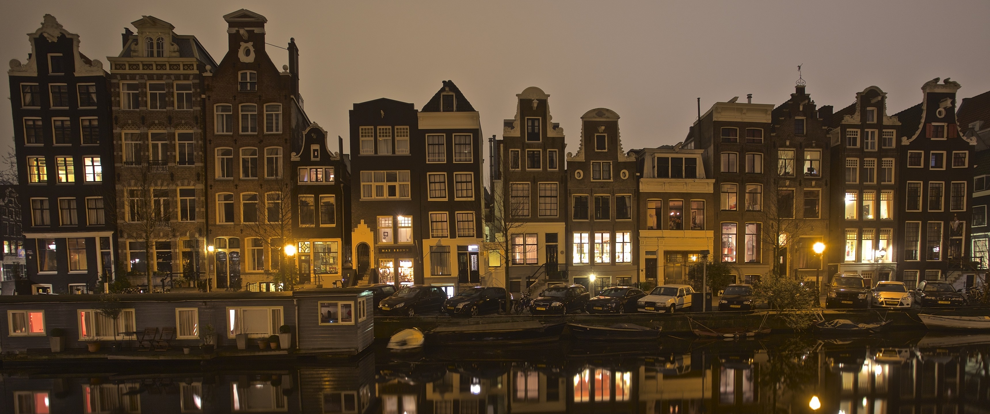Amsterdam canal houses at night with reflections HD Wallpaper