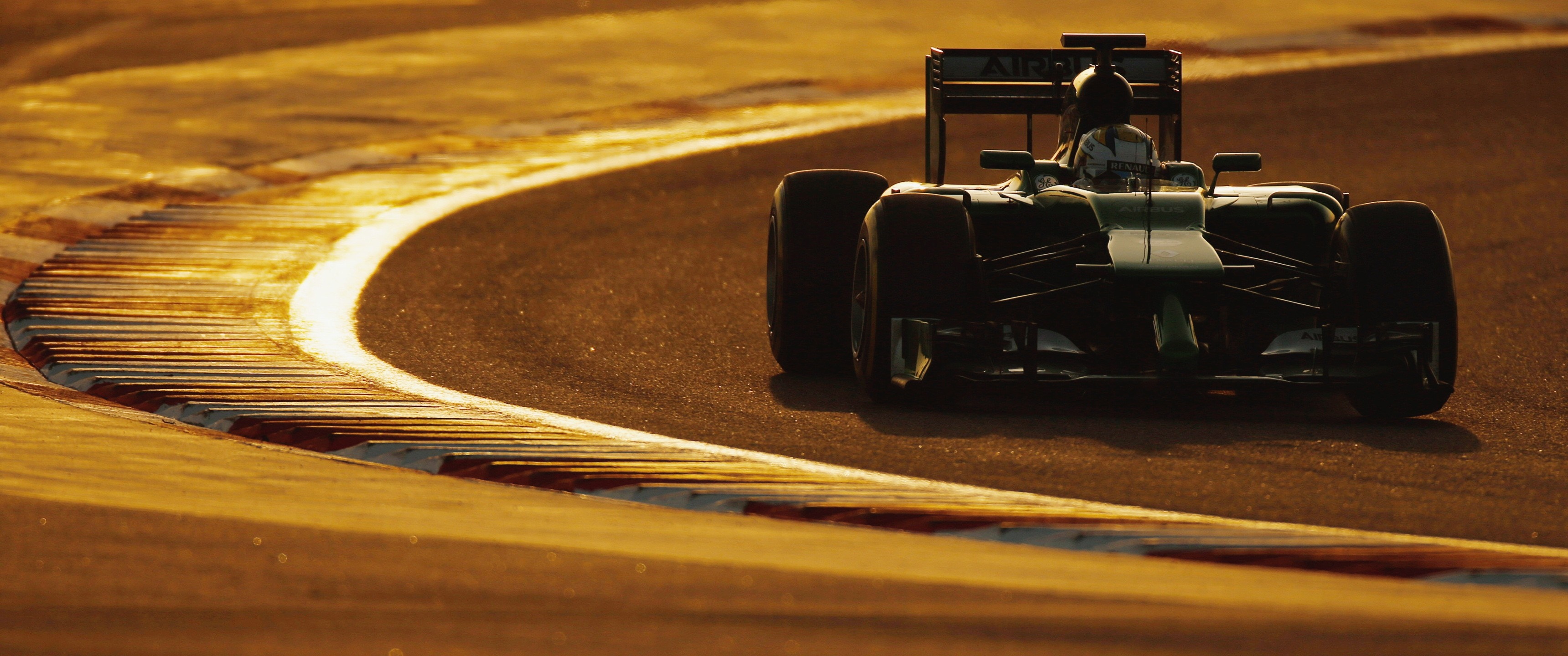 Formula 1 race car on a track at sunset HD Wallpaper
