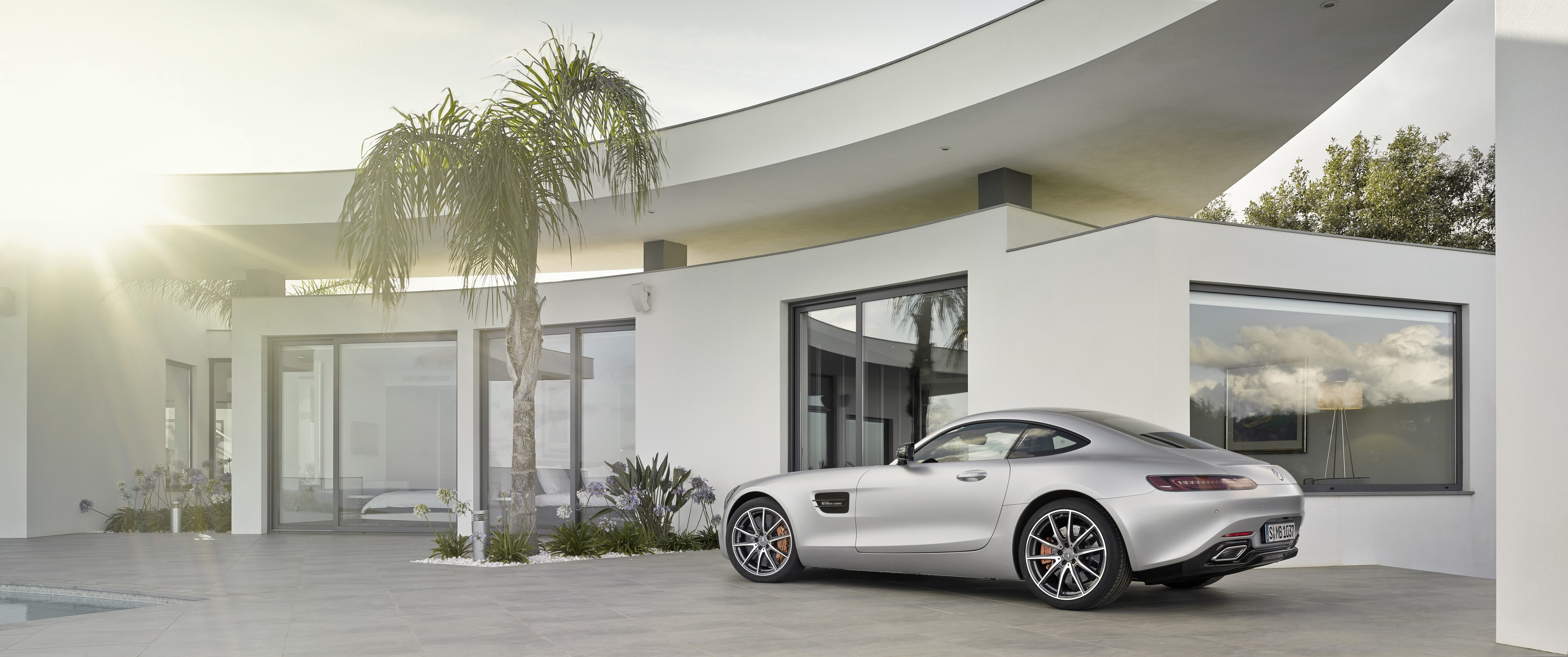Silver Mercedes-AMG GT parked in front of a modern white house HD Wallpaper