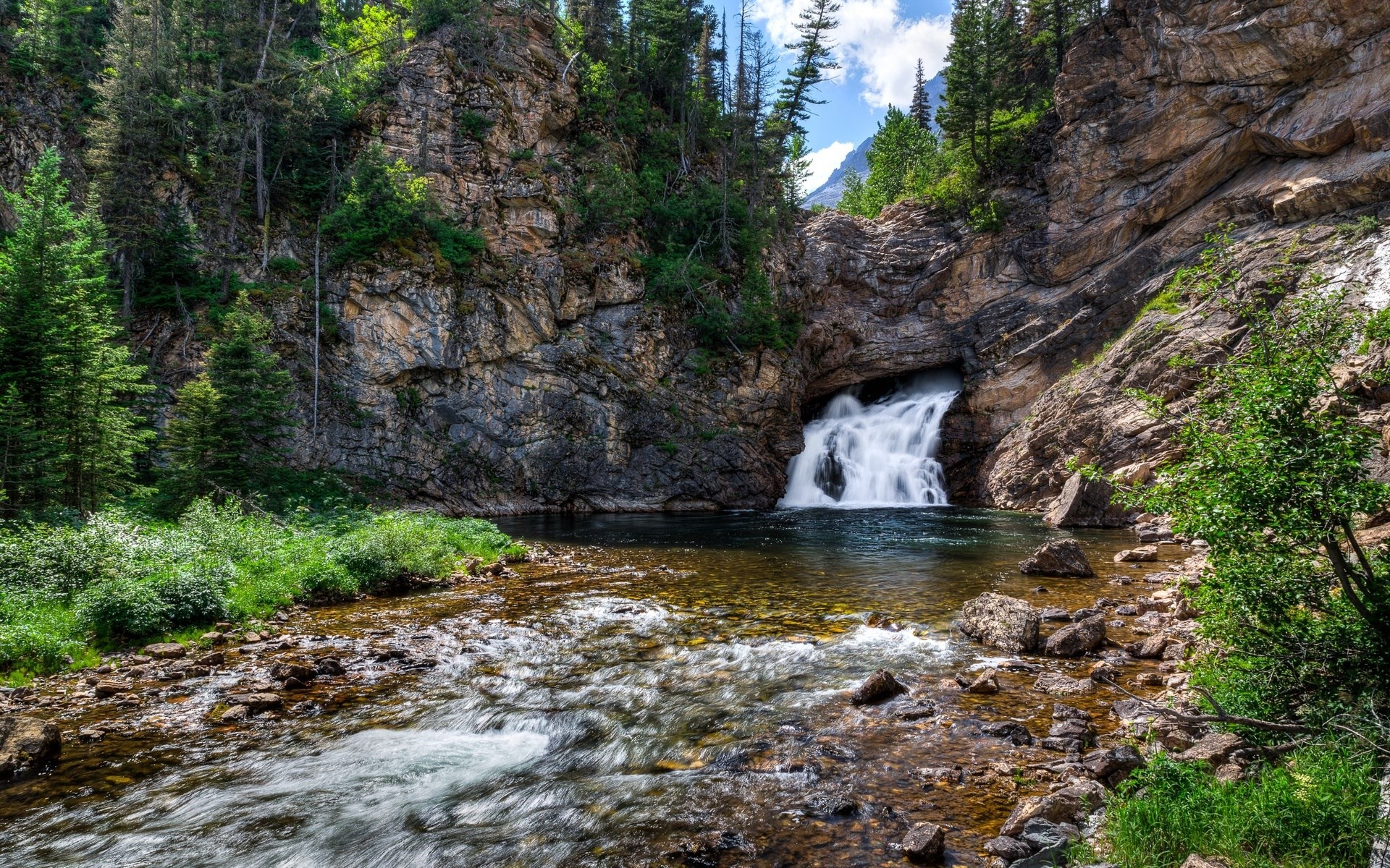 Waterfall cascading into a pool in a rocky gorge HD Wallpaper