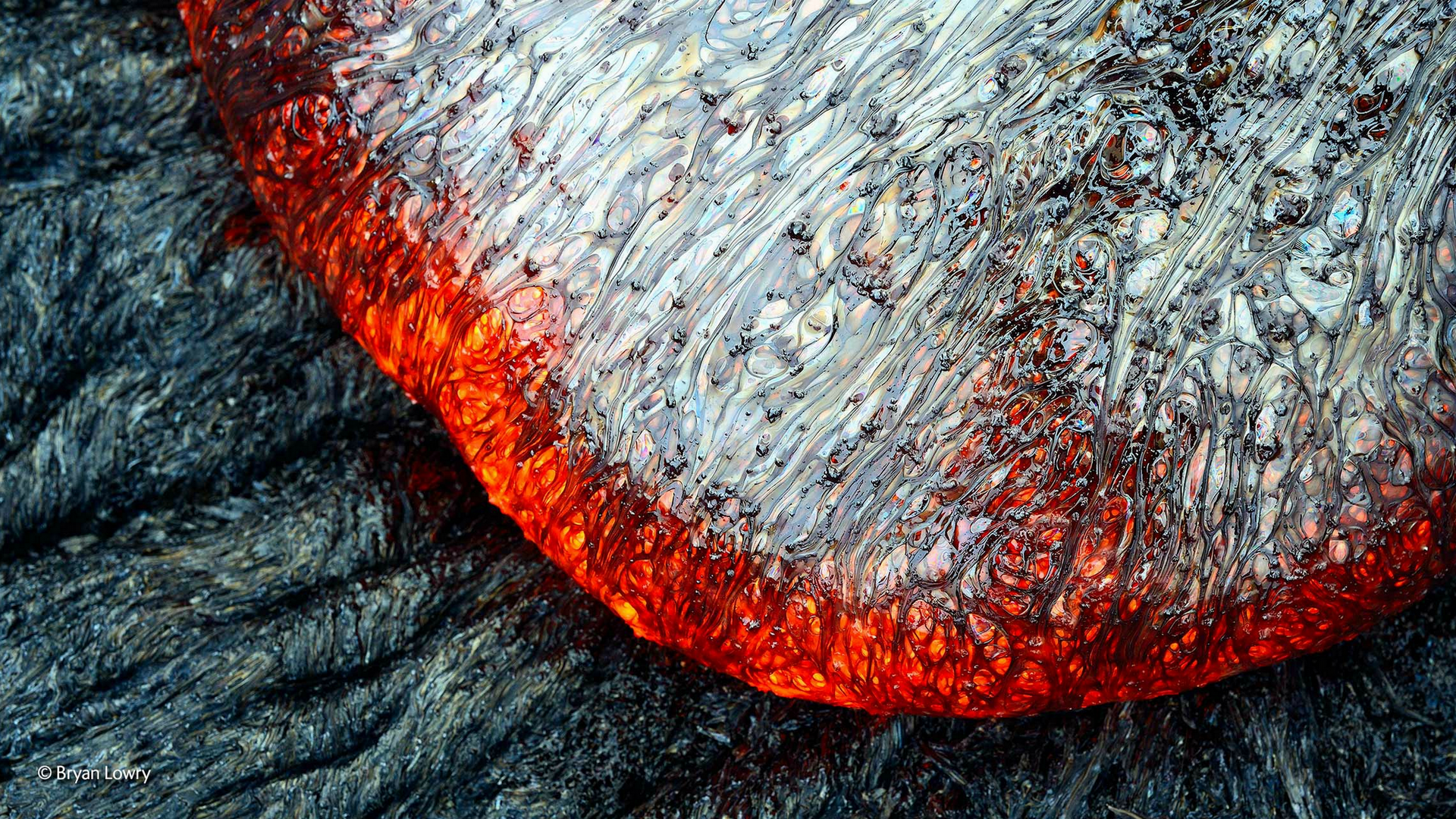 Close-up of molten lava flowing over cooled rock HD Wallpaper