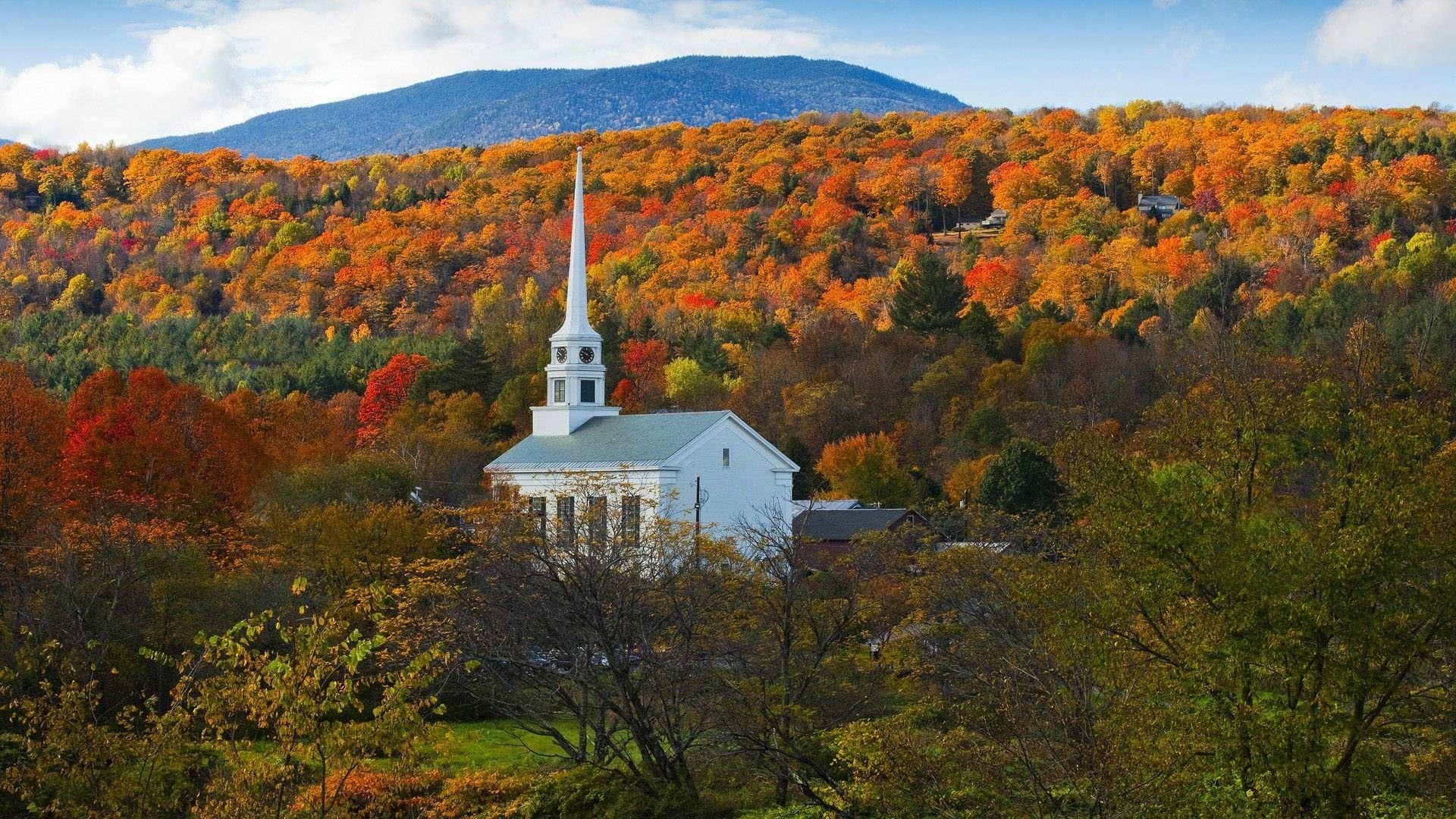 White church in autumn forest with mountains HD Wallpaper