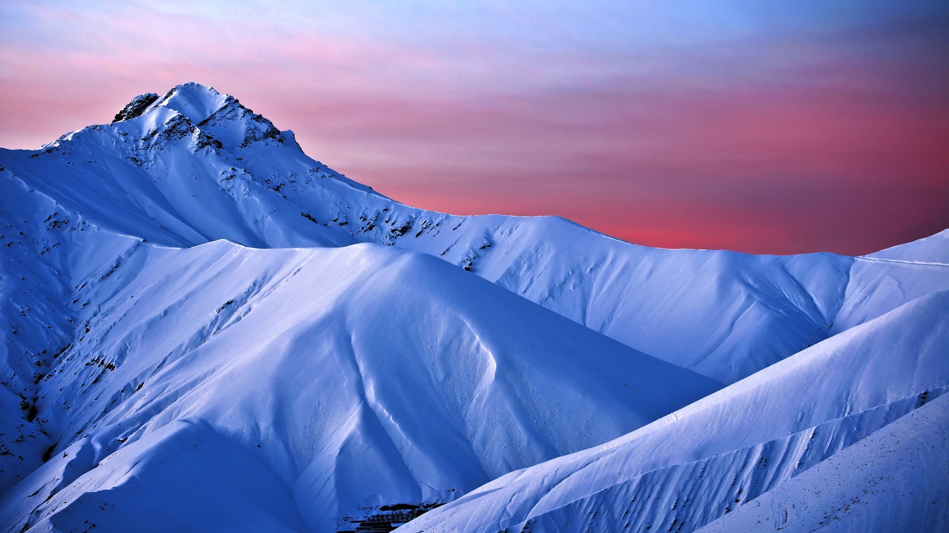 Snow-covered mountains under a pink and blue sky HD Wallpaper