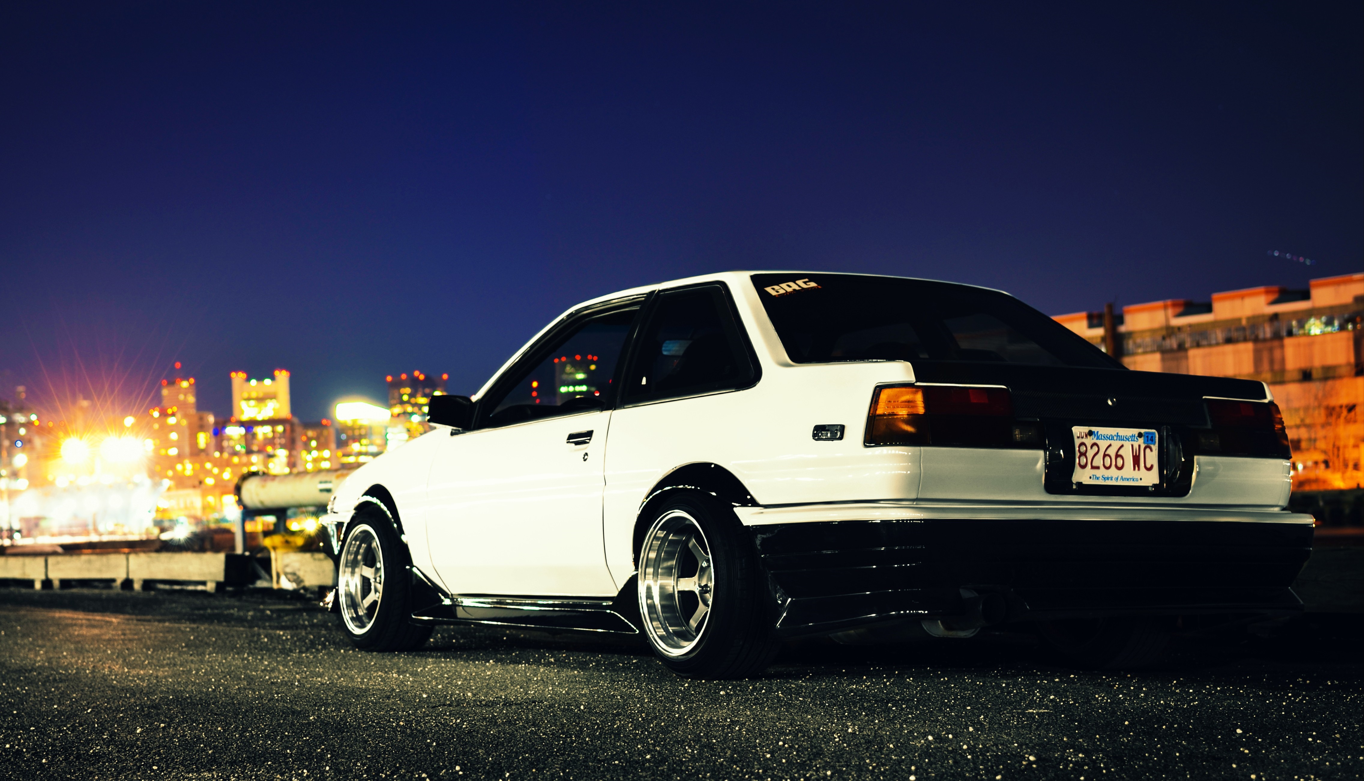 White Toyota AE86 sports car at night with city skyline HD Wallpaper