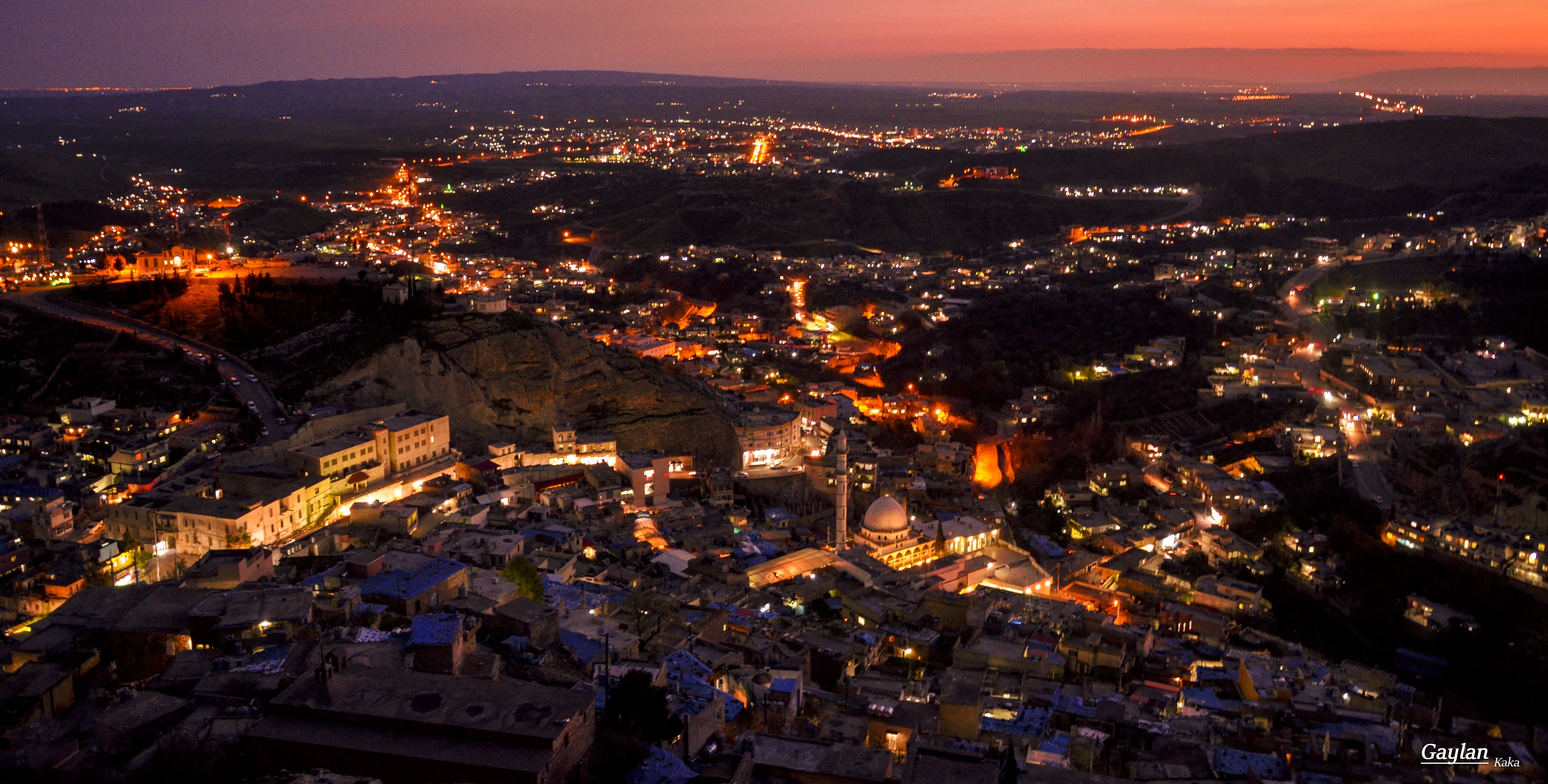 Aerial view of a city at dusk with lights HD Wallpaper
