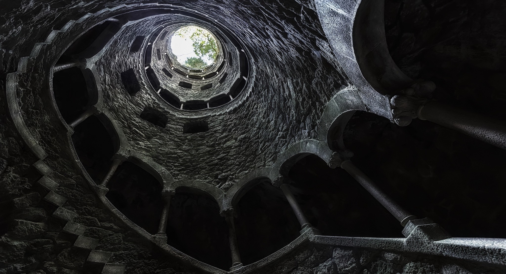 Spiral staircase in a stone well looking up HD Wallpaper