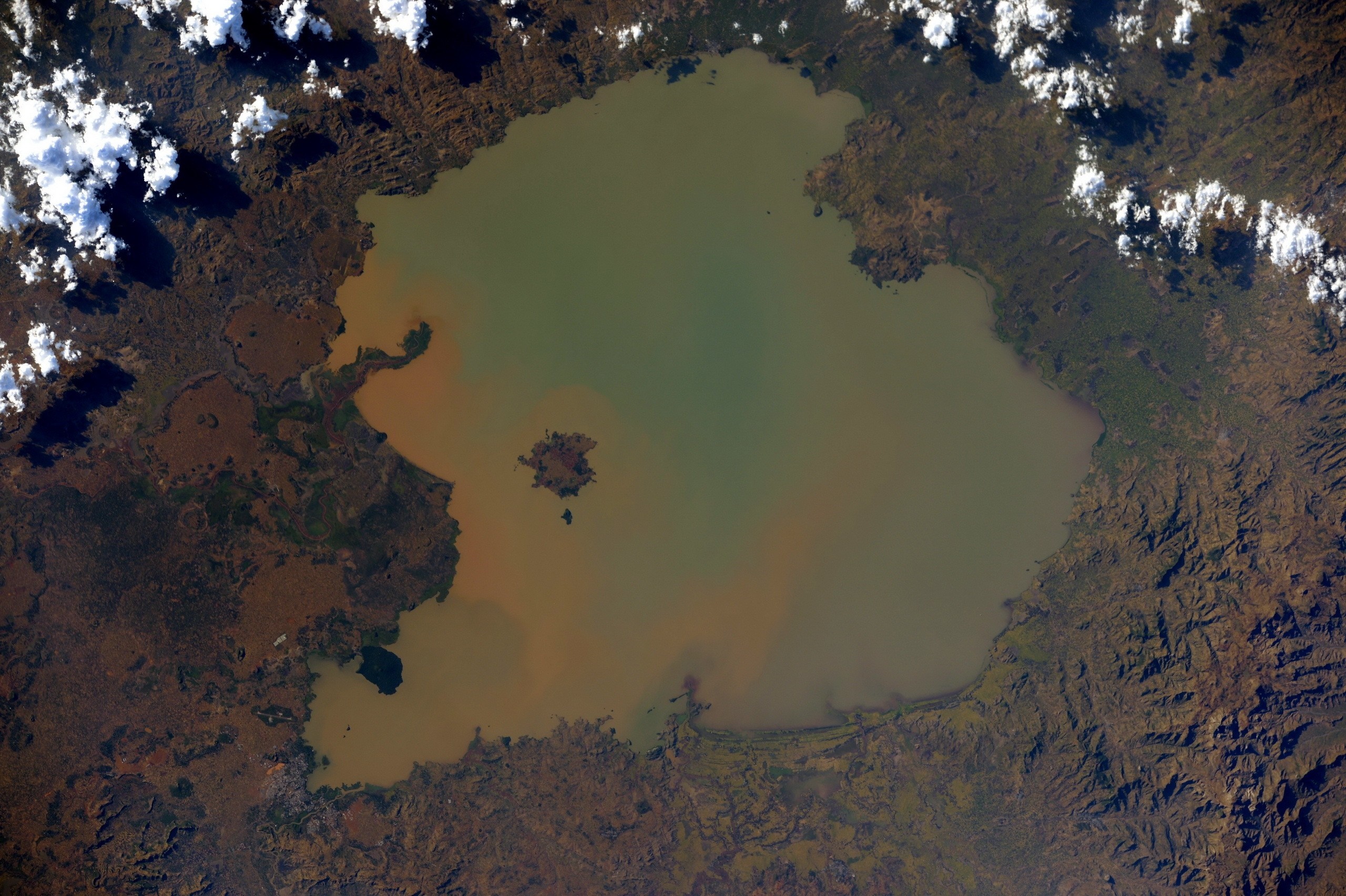 Aerial view of a large, muddy lake in Ethiopia with clouds HD Wallpaper
