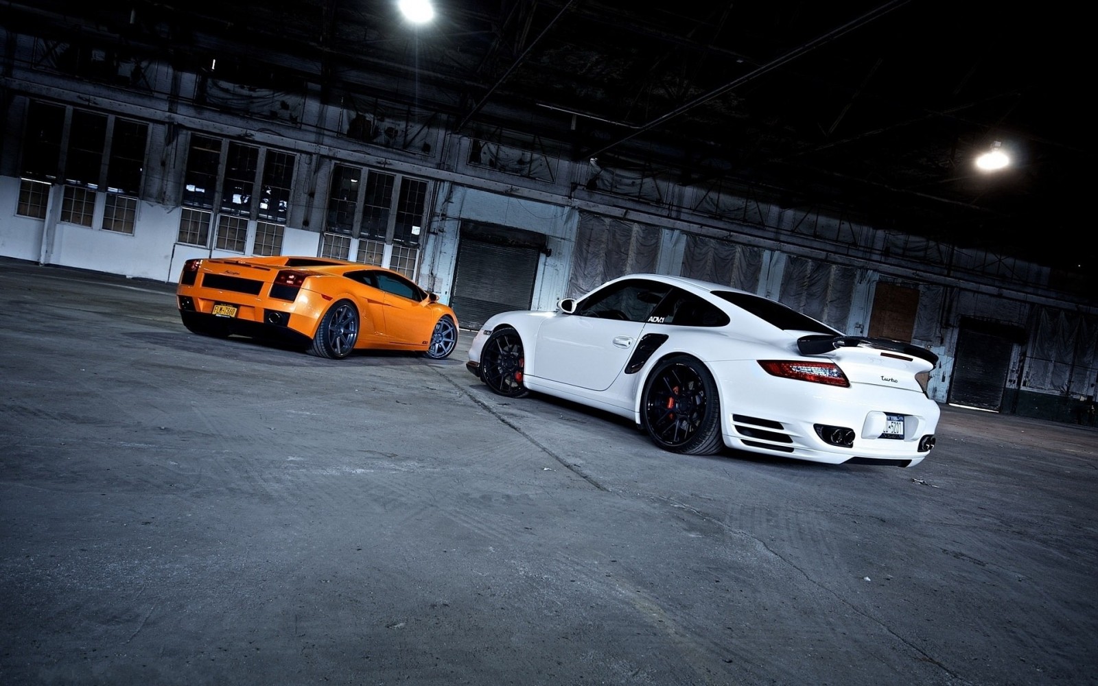 Orange Lamborghini and white Porsche in a warehouse HD Wallpaper